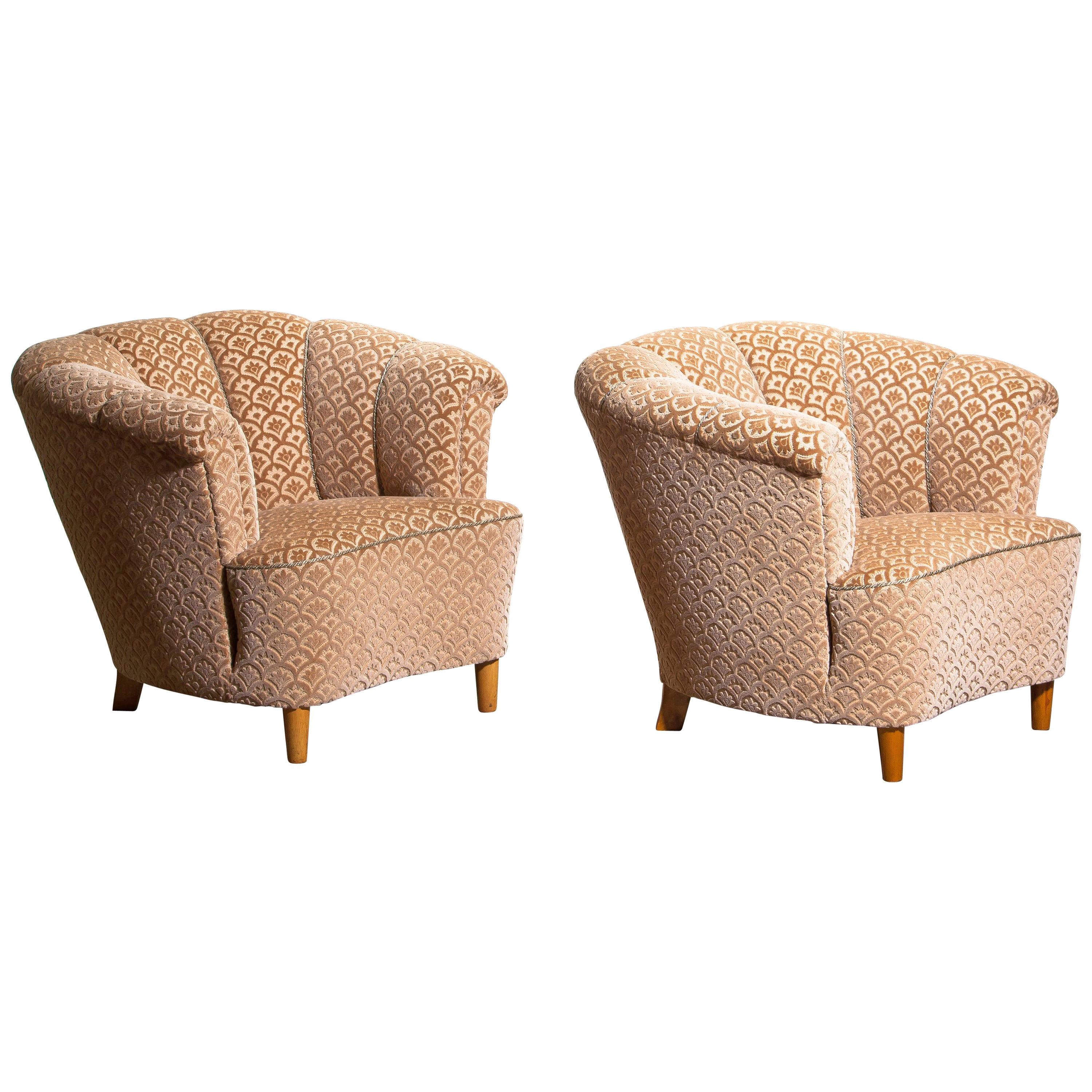 Beautiful set of two comfortable club lounge cocktail chairs from the 1940s.
Both chairs are in original and excellent condition.
The chairs are richly upholstered in flocked velvet and standing on beech legs.
 