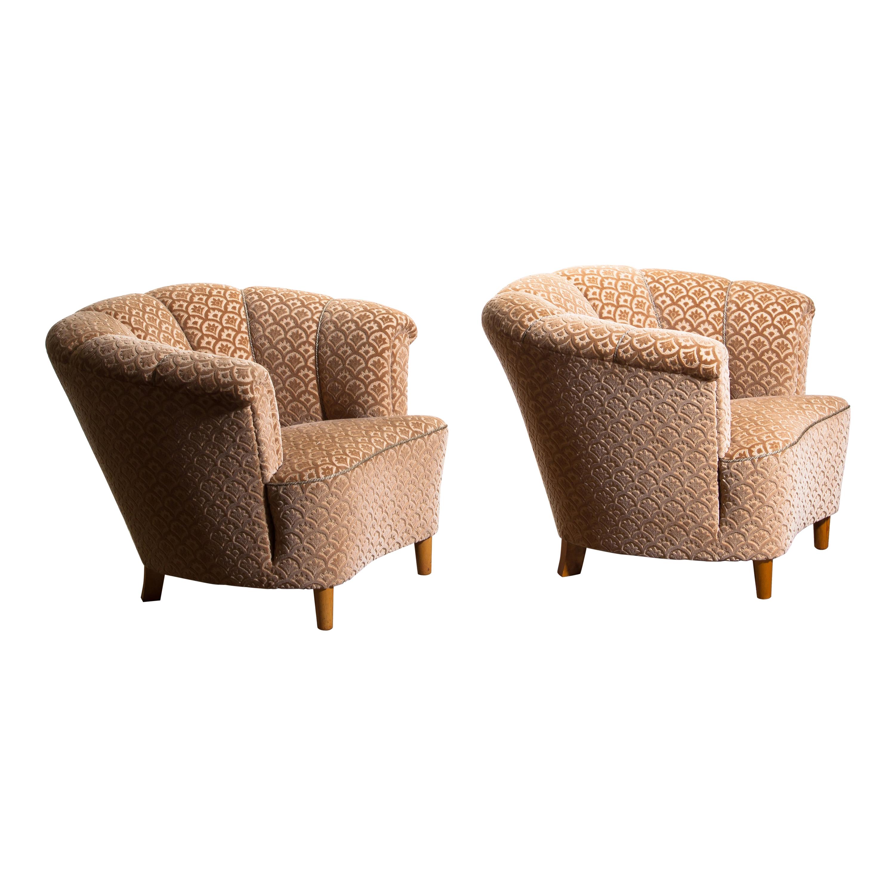 Beautiful set of two comfortable Club Lounge cocktail chairs from the 1940s.
Both chairs are in original and excellent condition.
The chairs are richly upholstered in flocked velvet and standing on beech legs.
  