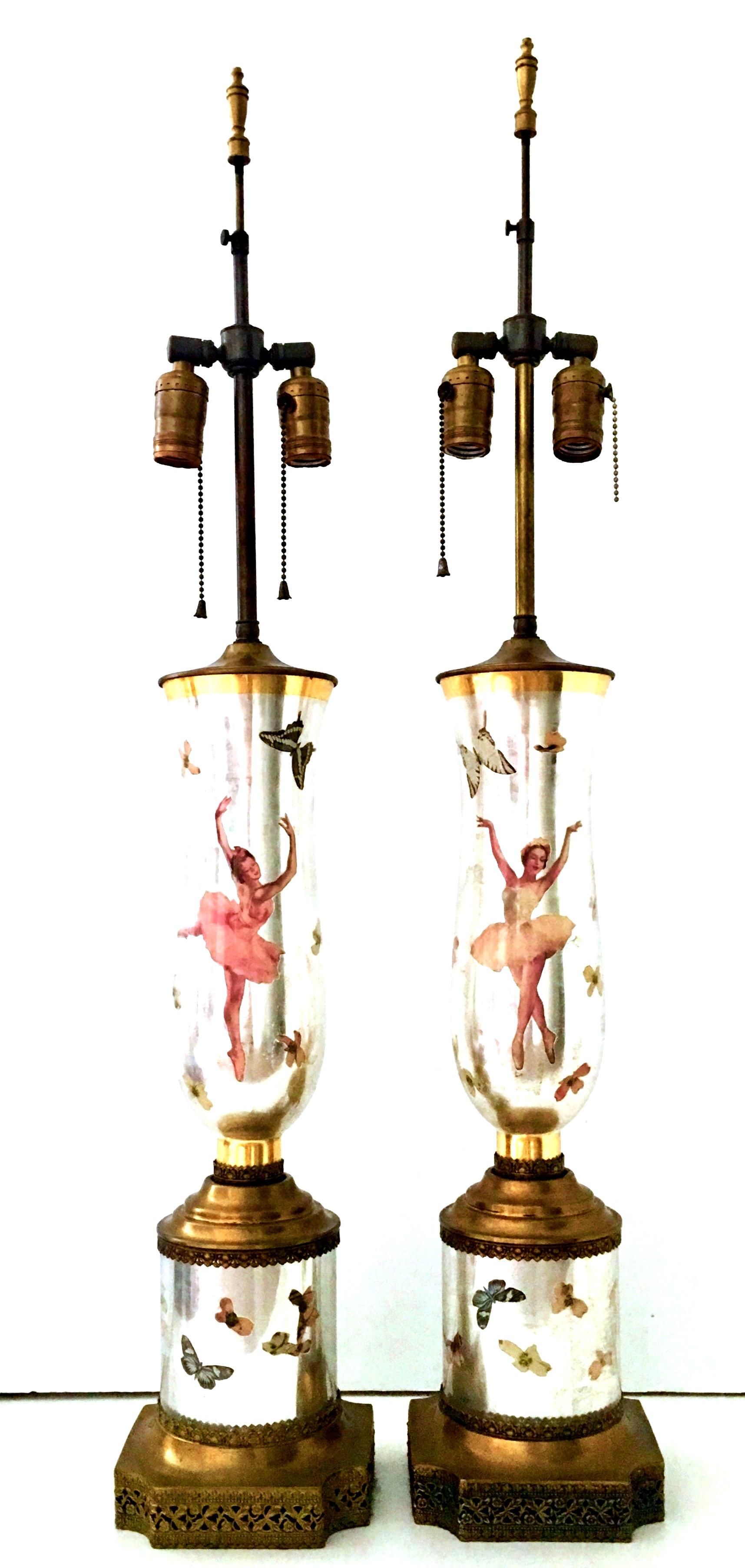 20th Century Pair of fine Art Deco silver leaf eglomise reverse painted art glass ballerina and butterfly decoupage lamps. Beautifully executed with original gilt brass filigree hardware and fittings. Double socket pull chain detail.
Wired for the