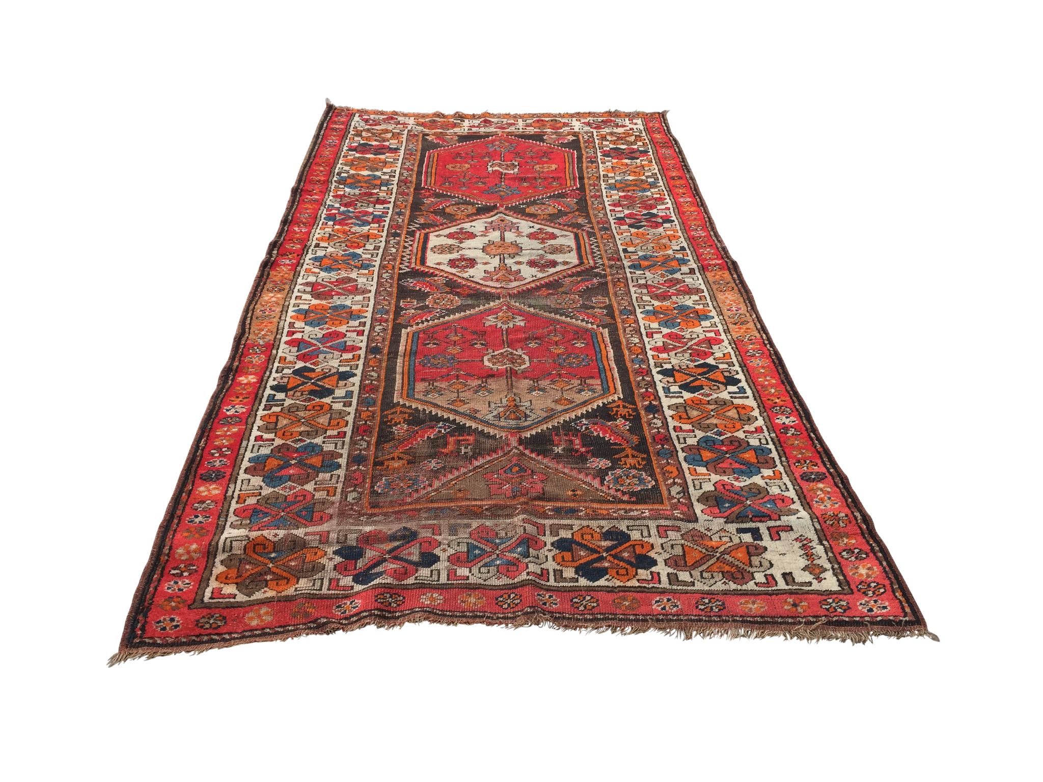An exceptional Persian runner rug, handwoven in the 1940s. A dynamic design comprised of three central medallions with floral and animal motifs. The wool is dyed in a striking palette of bright reds and oranges, with details in blues, beiges, and