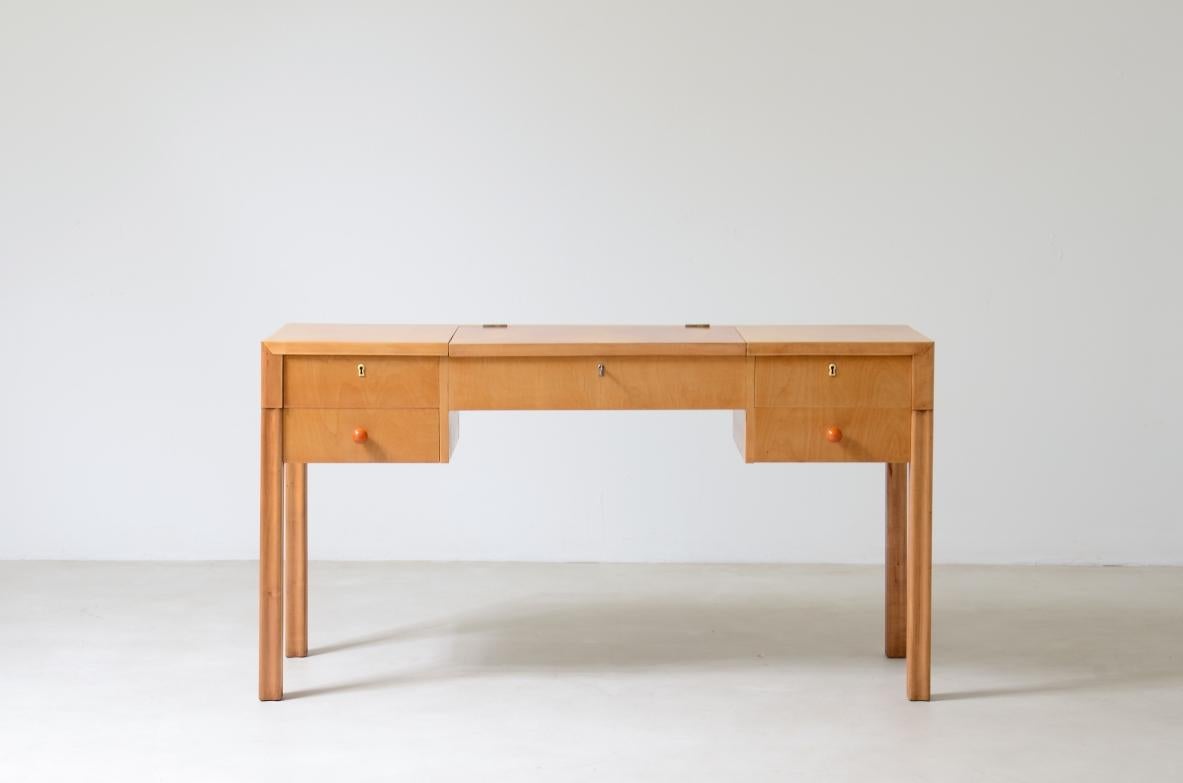 COD-2489
Console pétinoise en érable blond avec compartiment central et deux tiroirs sur les côtés. Pieds rainurés et boutons en galalithe.

Label du fabricant.

Cav. Serafino Arrighi, mobilier d'art Cantù, années 1940.