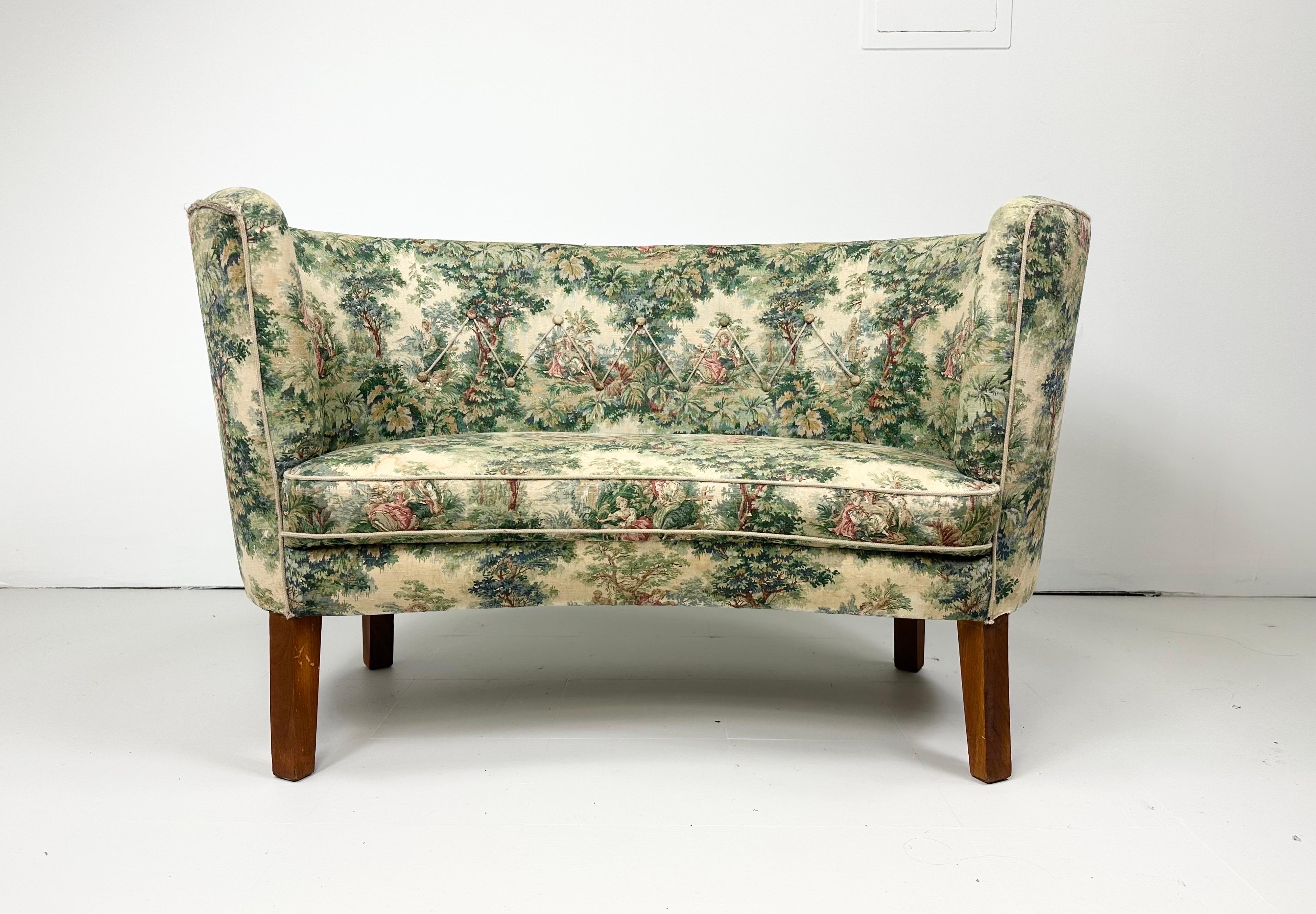 Petit 1940's Danish Upholstered Bench with wood legs. Bench is slightly curved and in the style of larger classic Danish sofas of the same period. Original upholstery. 

We can assist with delivery to NYC. Please inquire.