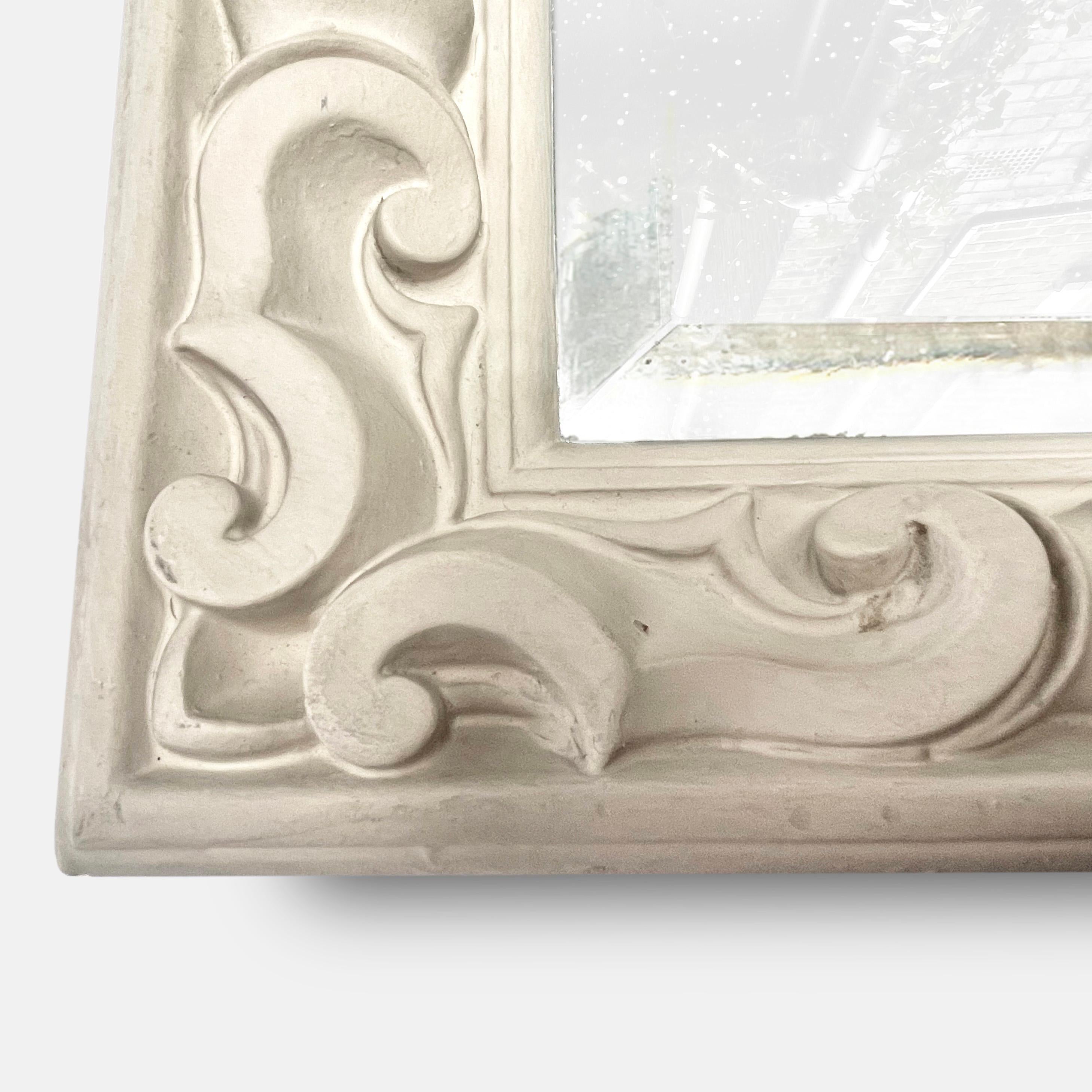 Dating from the 1940s, this beautiful, cream, stucco mirror in the manner of Serge Roche shows perfectly the three design elements of which he never tired: Mirrors, stucco, and curves.
 The bevelled reflections of the mirrored glass are placed in