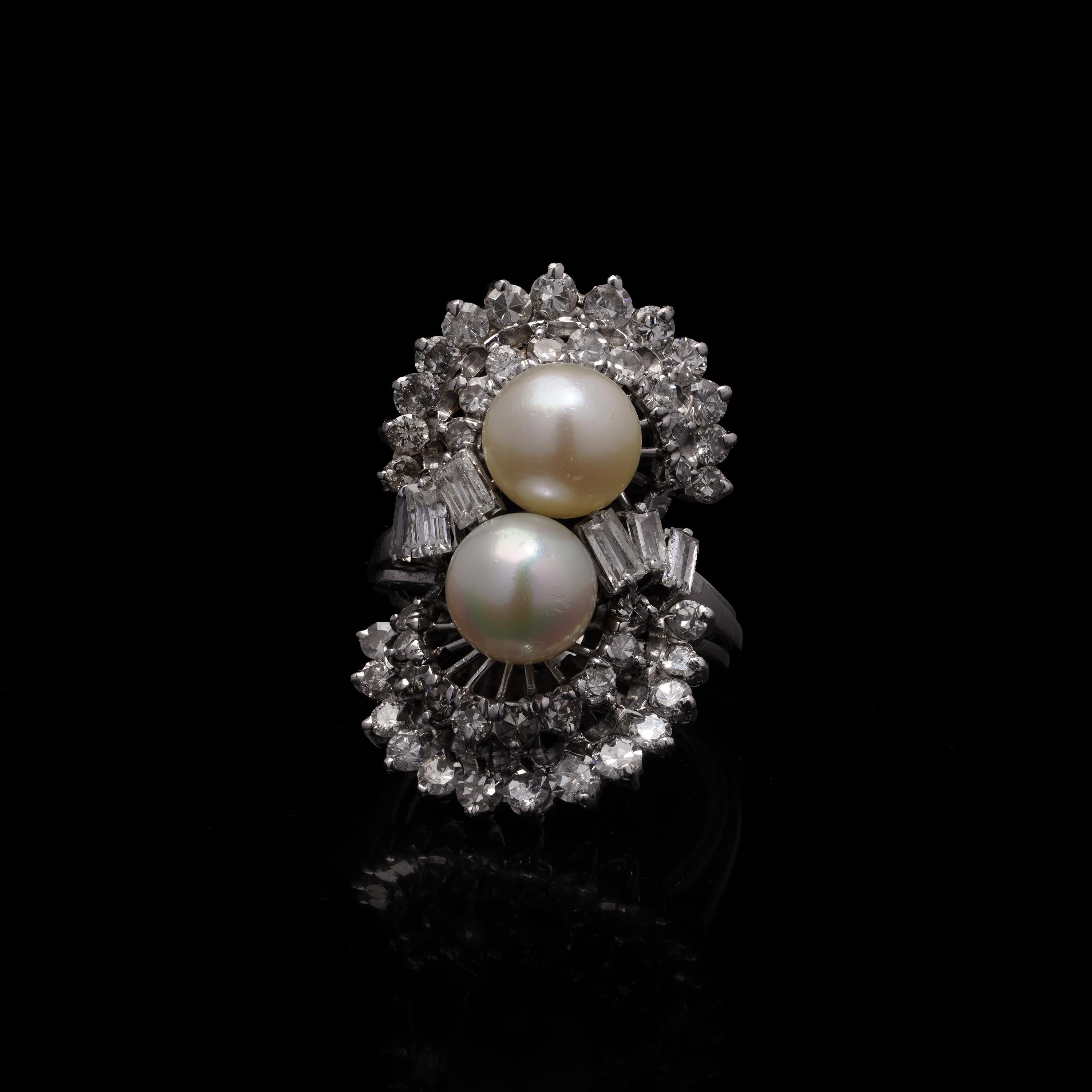Anello doppio a grappolo da donna in platino degli anni '40 con perle d'acqua dolce e diamanti

Questo elegante anello in platino degli anni '40 presenta due splendide perle d'acqua dolce incastonate in un'abbagliante serie di diamanti. Ogni perla