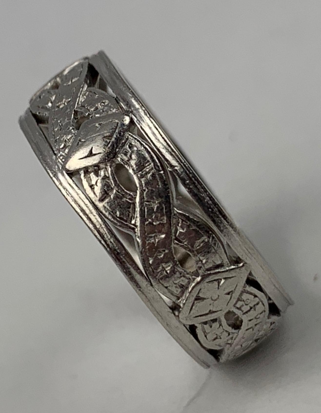 Created for a wedding in 1941 this platinum wedding band has a design of criss crossed bands with a diamond shape at every other intersecting point.  Marked on the inside 