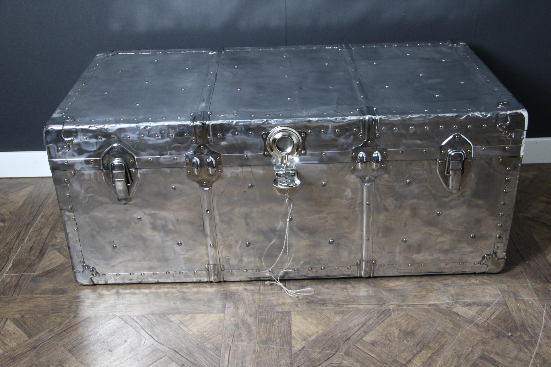 This polished aluminum cabin trunk is very unusual.
It is magnificent mirror hand polished. It features all brass studs and original leather side handles.
It still has got its key for its main lock.
Its interior is all original too with its