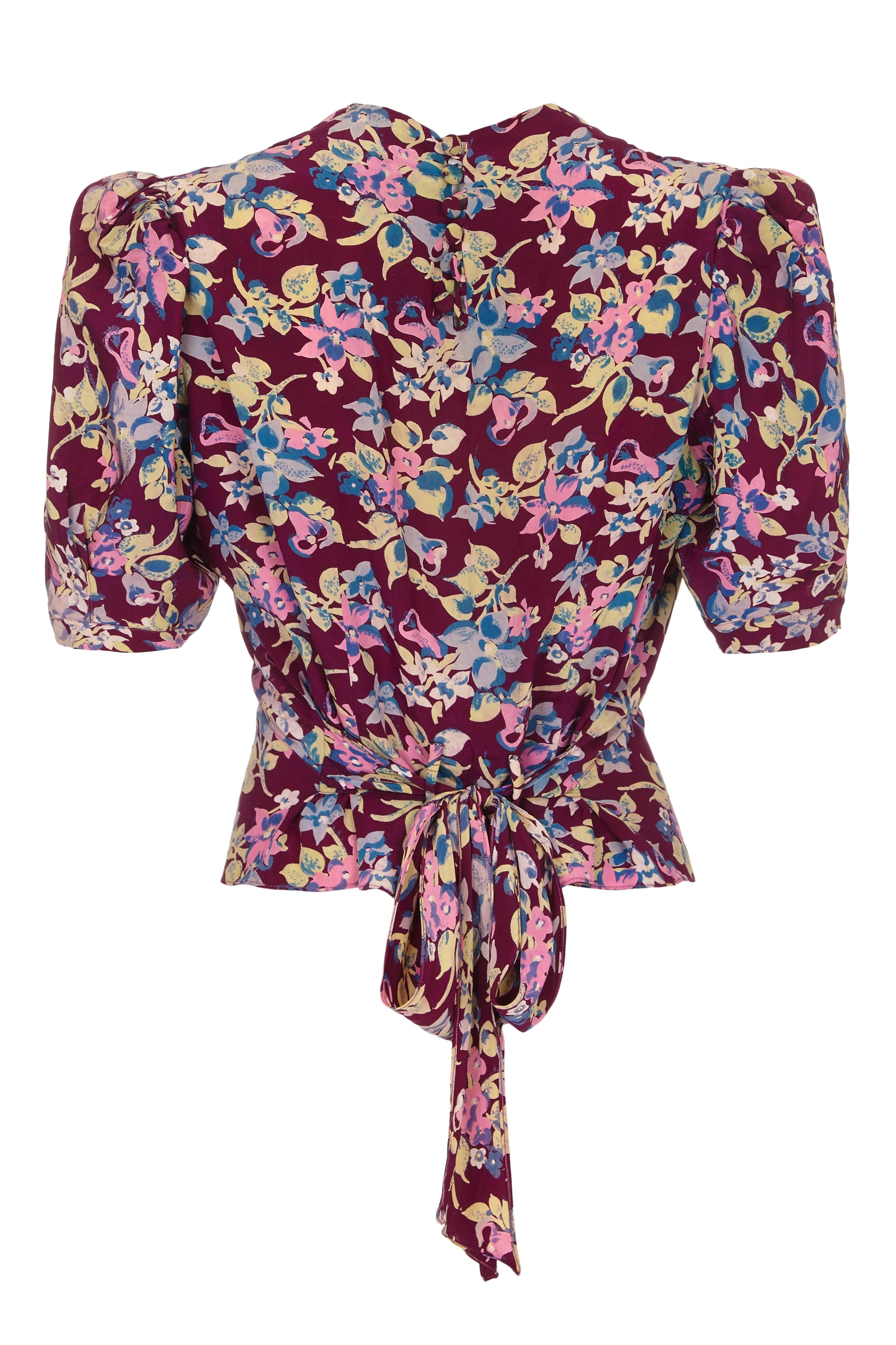 Original vintage floral print silk blouse with an unusual colour combination from the early 1940s.  This is a beautiful example and features elbow length puff sleeves, pretty covered button and loop detail on the back and a tie to pull in the