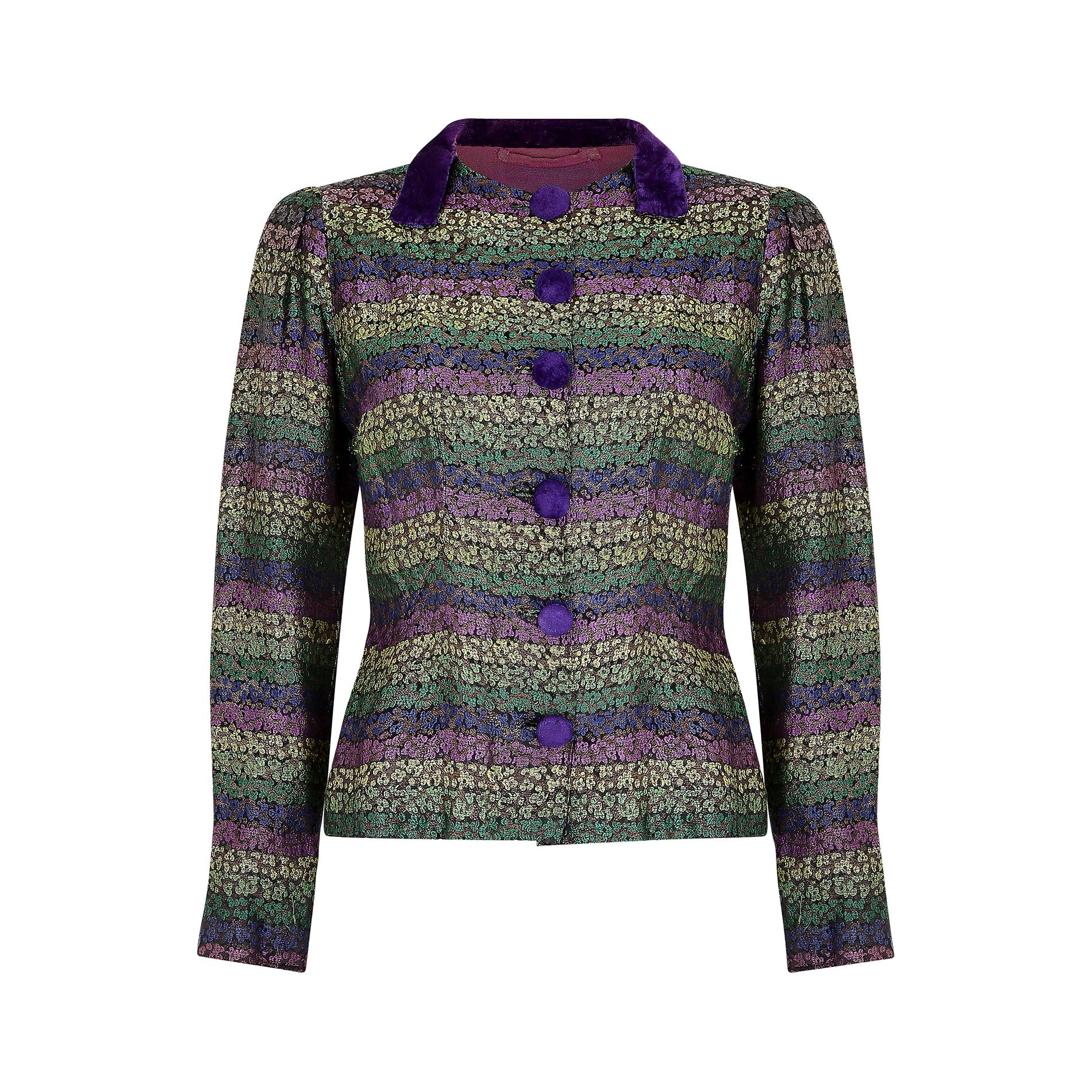 This original 1940s lame jacket fastens at the front with six buttons, each covered in a bright Royal purple silk velvet. The high neckline features a neat collar comprised of velvet fabric and the shoulders are slightly gathered and padded to add a