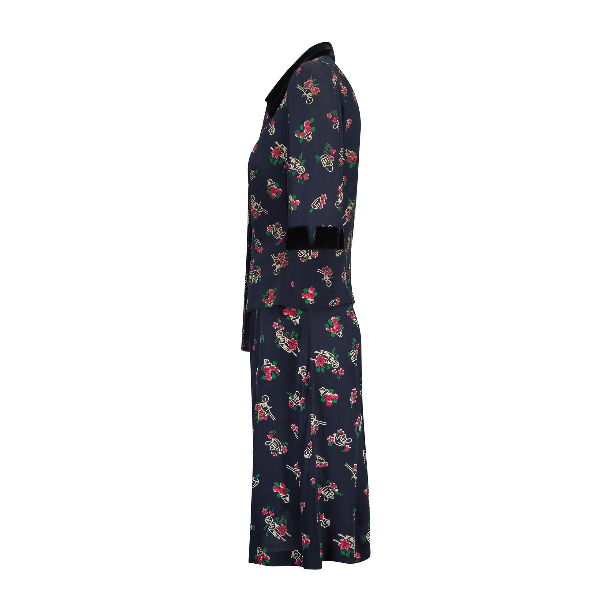This 1940s novelty cold rayon skirt suit is tailored to a pretty and feminine tea-dress style, typical of this era. Both pieces are tailored from a midnight blue cloth which looks almost black, patterned with gardening tools - very unusual! Printed