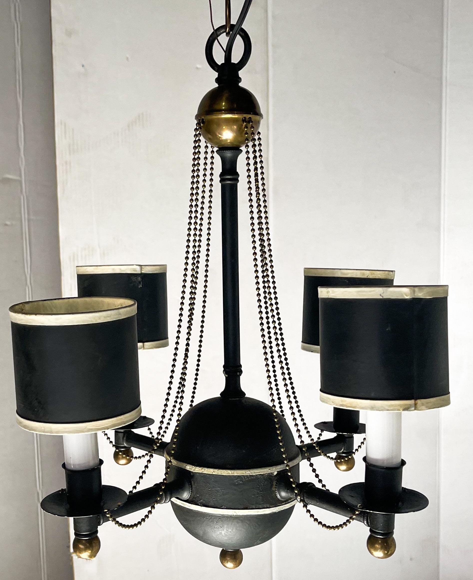 I love this fixture! It is a petite regency style chandelier that has just returned from being cleaned and re-wired. It has four arms, and the shades are original. The chain is six feet and new. It is unmarked.
