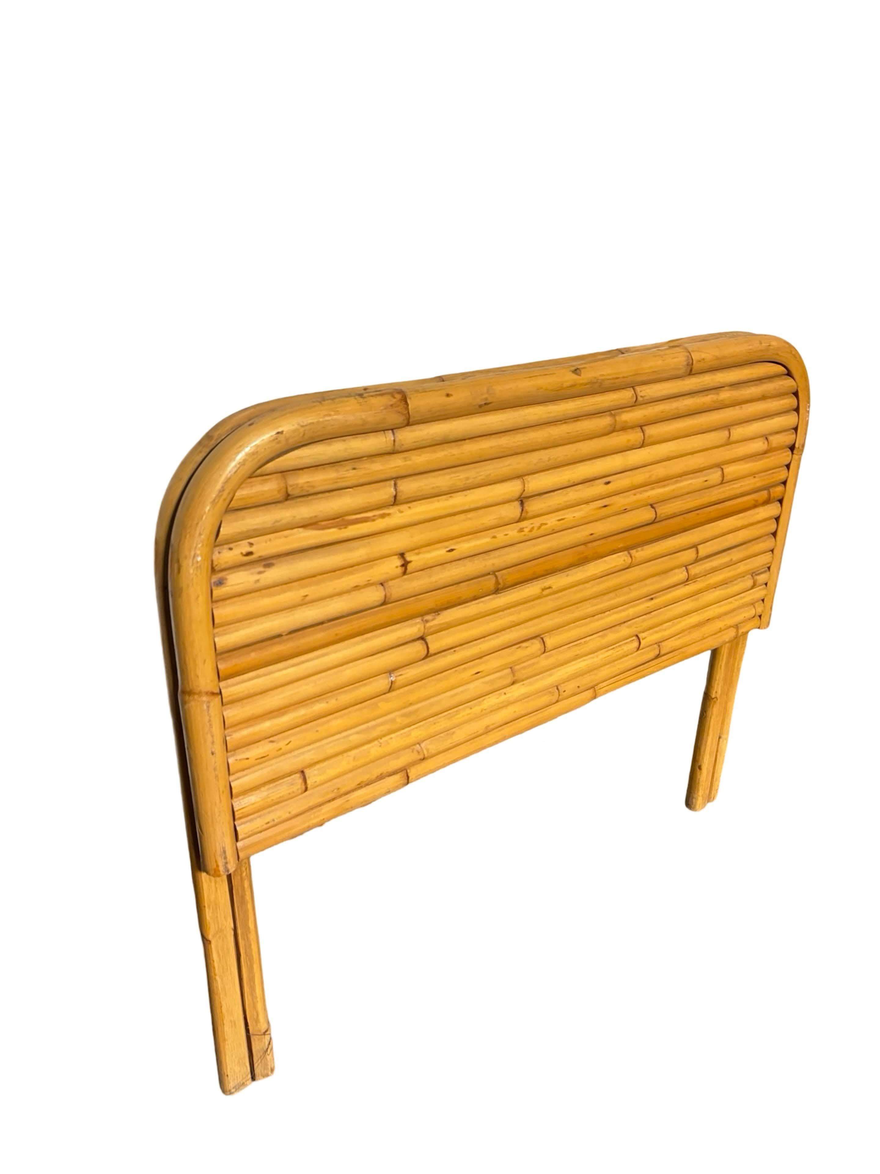 Questa splendida testiera in rattan impilata ispirata a Paul Frankl, splendidamente restaurata, cattura l'essenza dell'era Art Déco. La testiera è realizzata con un design in rattan a 12 fili impilati orizzontalmente con doppie gambe laterali.