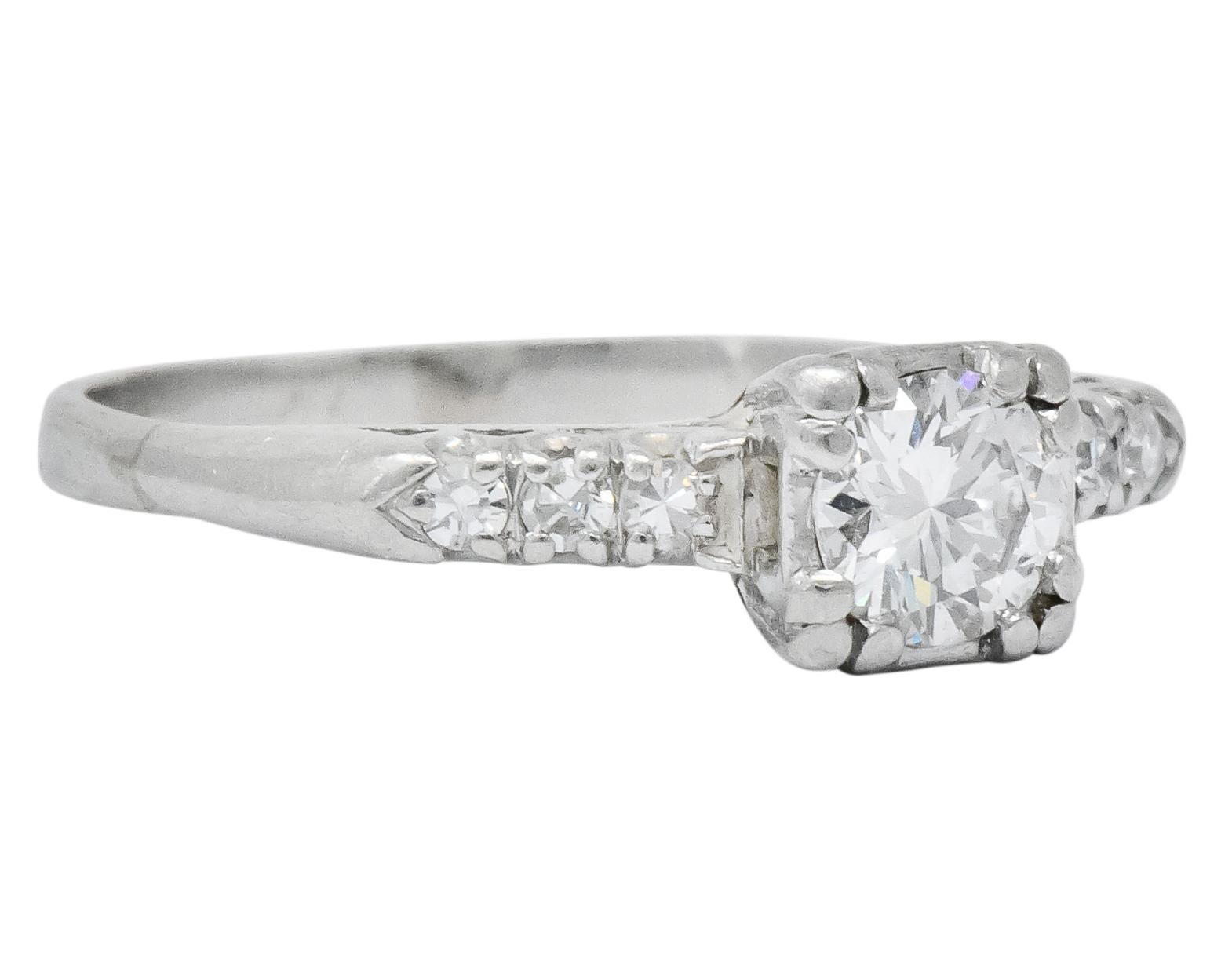 Centering a round brilliant cut diamond weighing approximately 0.40 carat, H color and VS clarity

Flanked by three single cut diamonds on each side, all six weighing approximately 0.10 carat total, eye-clean and white

In a tri-split prong, square