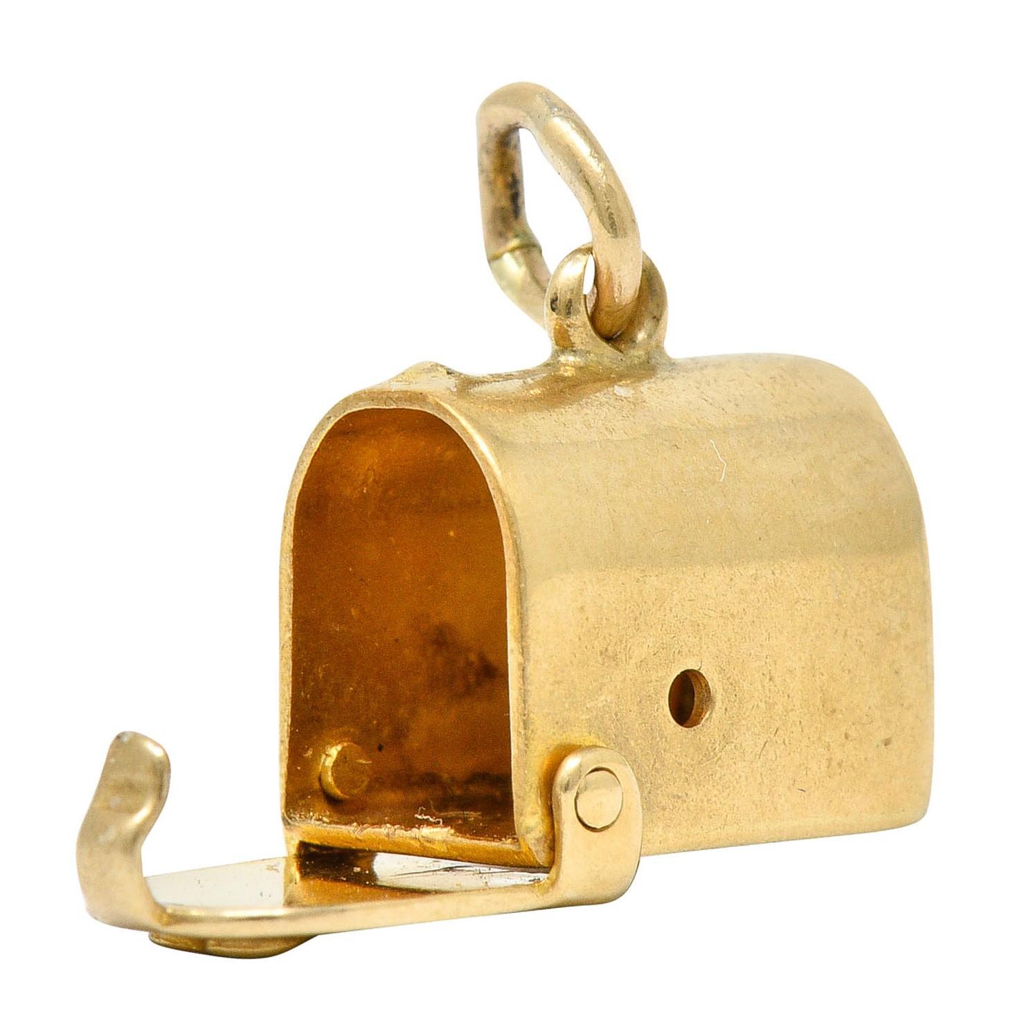 Designed as a planished mailbox form

With a front facing heart on its door

Which opens on a hinge

Completed by a jump ring bale

Stamped 14K for 14 karat gold

Circa: 1940s

Measures: 1/4 x 3/8 inch

Total weight: 1.4 grams

Deliverable.