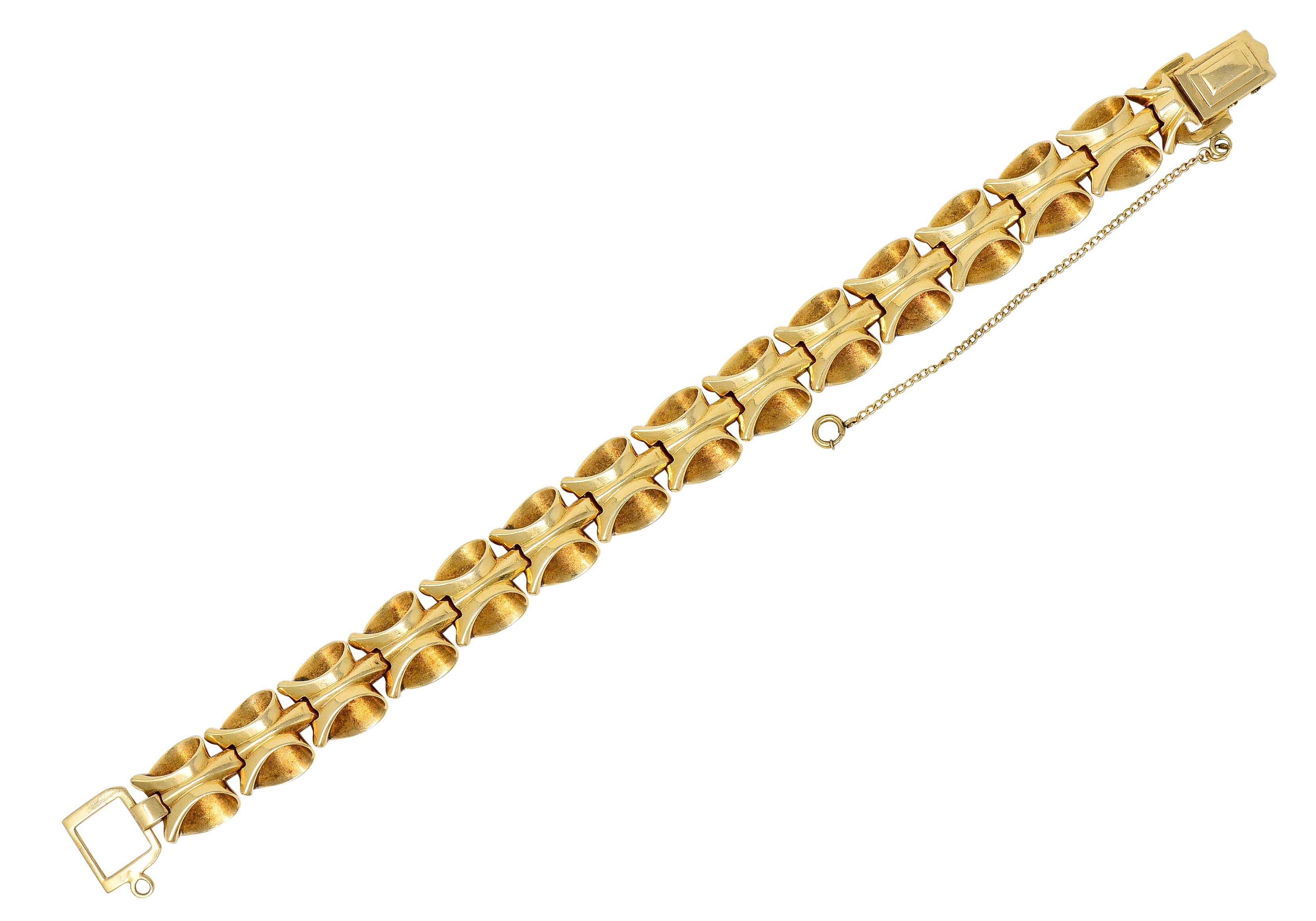 Bracelet is comprised of dynamically formed links as stylized ribbon-like loops

Contrasting a bright finish with inner brushed finish

Completed by fold-over clasp with chain safety

Stamped 14K for 14 karat gold

Circa: 1940s

Length: adjustable