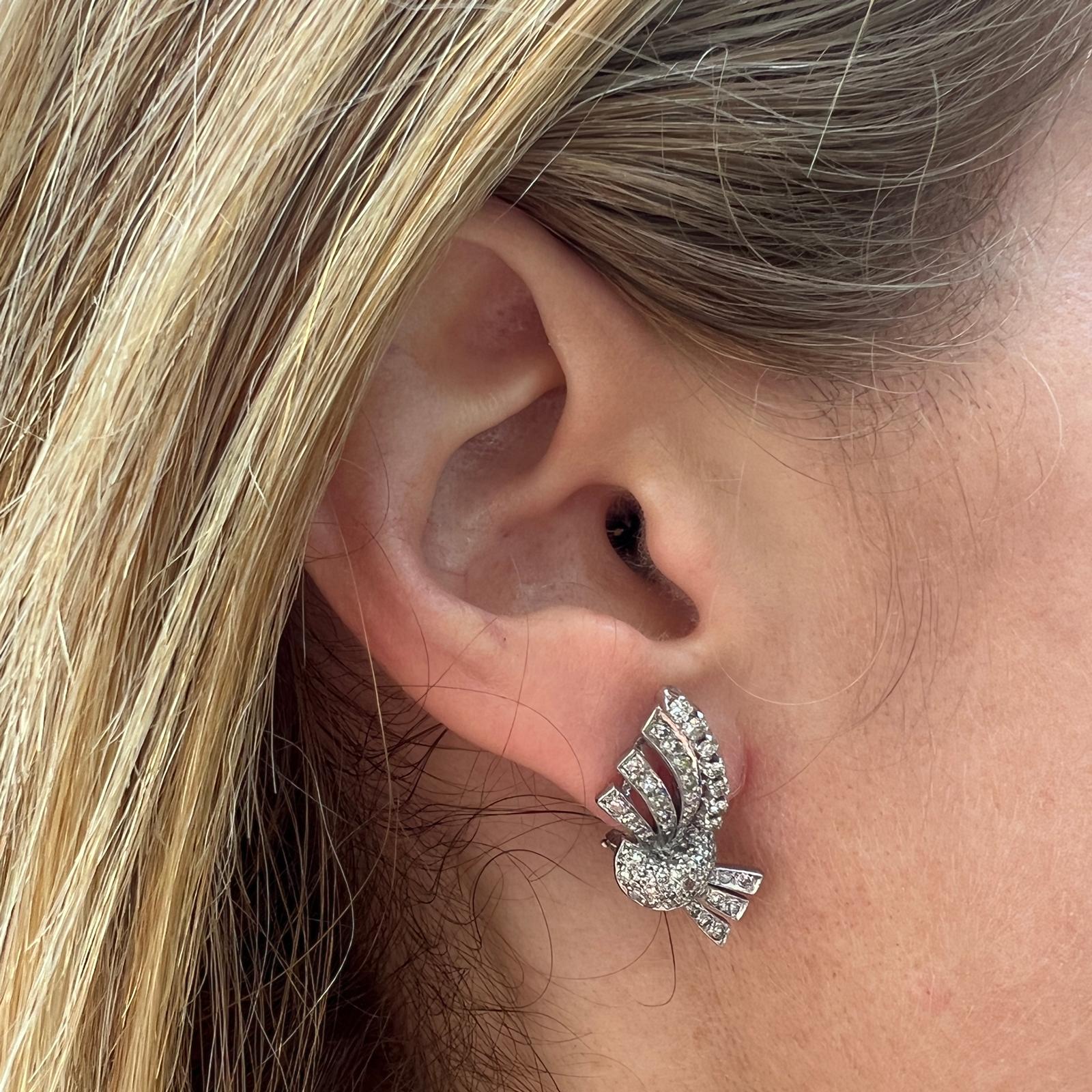 Beautiful and feminine original Retro diamond ribbon earrings handcrafted in platinum. The earrings feature 90 single cut diamonds weighing approximately 1.50 carat total weight and graded H-I color and SI clarity. The earrings measure 10 x 30mm