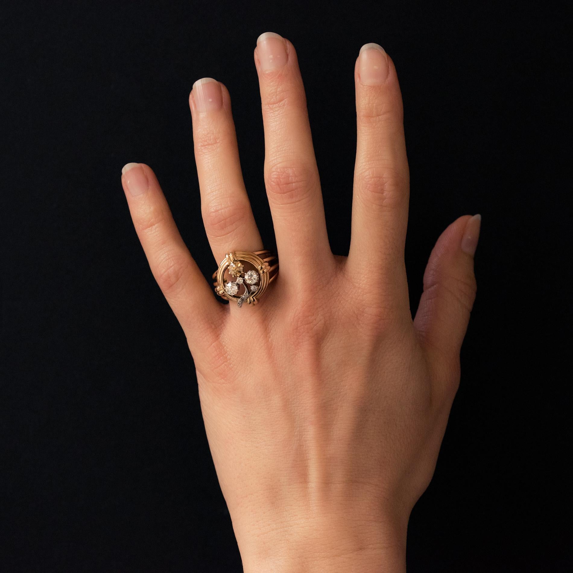 Ring in 18 karat yellow gold.
The top of this splendid antique ring represents a clover whose leaves and foliage are set with antique-cut diamonds, white and a beautiful cognac diamond. The entire periphery is made up of gold threads held at the