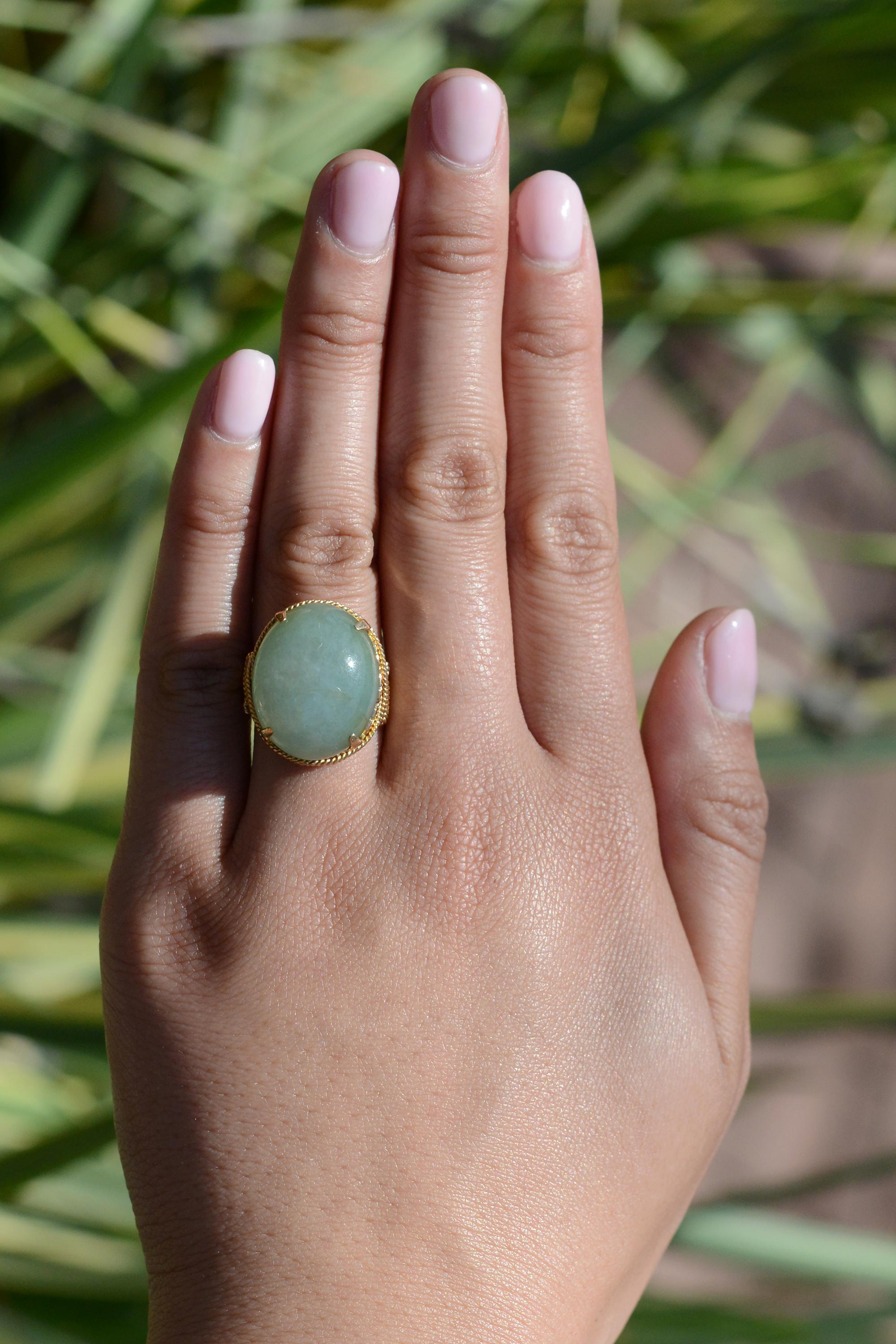 This affordable authentic 1940s vintage Retro cocktail ring is a true collector's item. Crafted in 18k gold with a lovely, rosy patina and centered by a large oval jade cabochon of an alluring, soothing sea foam green. A classic statement ring sure
