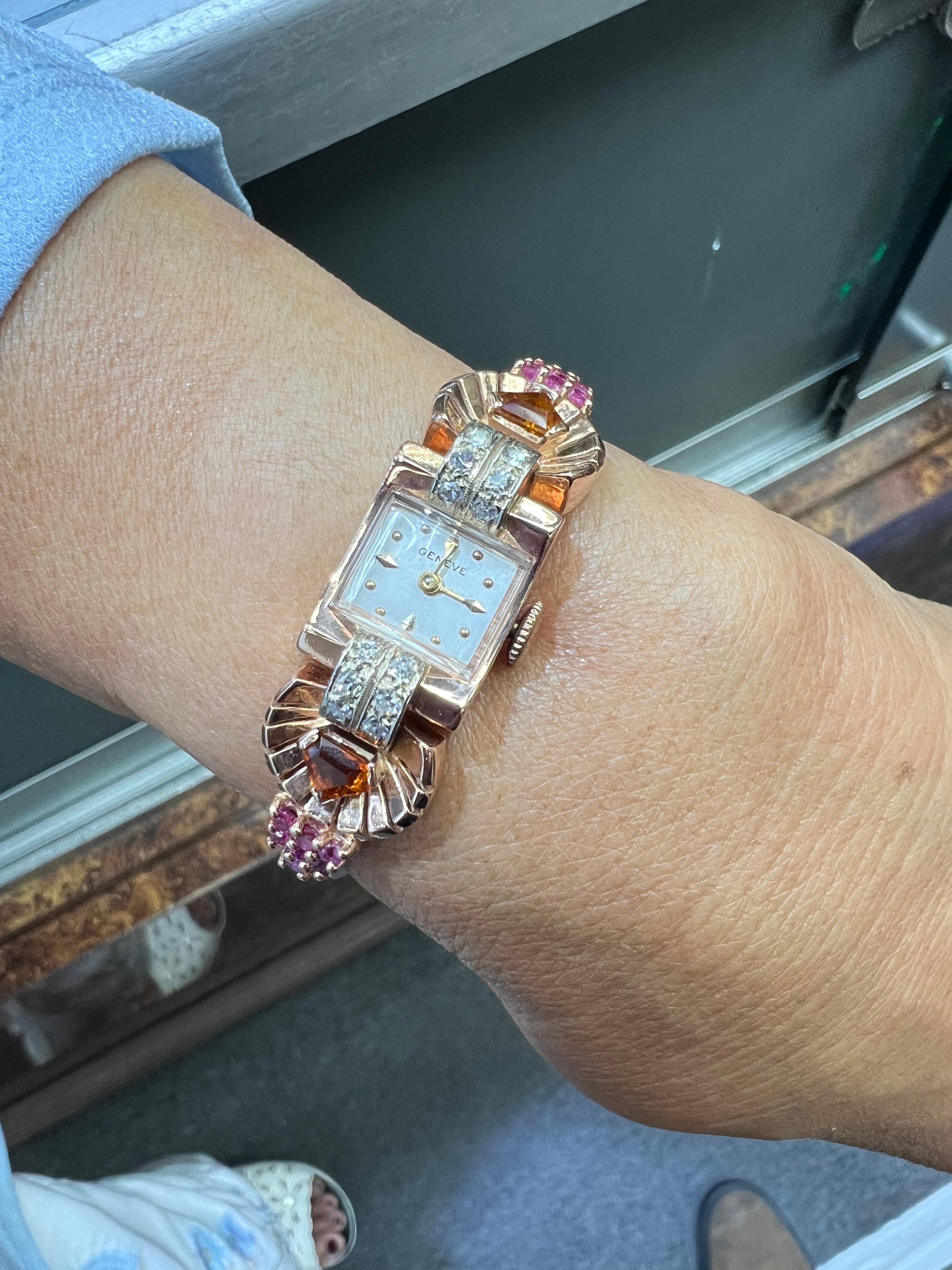 Reloj de pulsera retro de oro rosa de los años 40 con citrino, rubí y diamantes.

Este precioso reloj de pulsera Retro de oro rosa de 14 quilates con citrino, rubí y diamantes se fabricó en la década de 1940.  Alberga un movimiento manual Geneve de