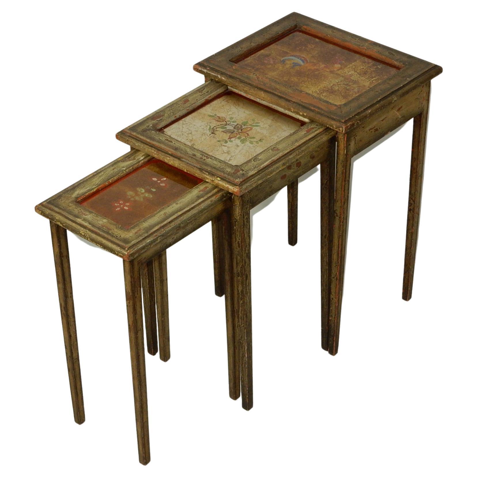 Unique, one of a kind, circa 1940's artistic nesting table set.
Reverse painted floral design glass tops with gold or silver leaf background.
Frame and legs have textured painted surface.

 