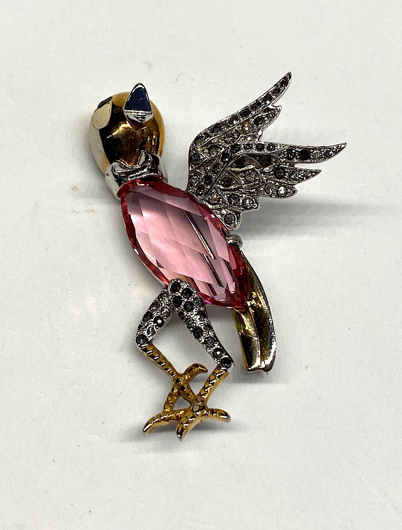 A charming figural brooch of a bird chirping from the 1940s. The head, tail and feet are gold plated while the wings, collar and thighs are rhodium plated. The wings and thighs are set with rhinestones. Most have darkened over time. The head has a