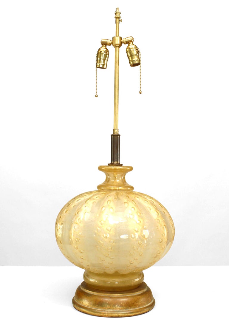 Italian 1940's Venetian large, bulbous table lamp composed of iridescent gold Murano glass formed with decorative tonal striations and air bubbles resting upon a round gilt wood base.
