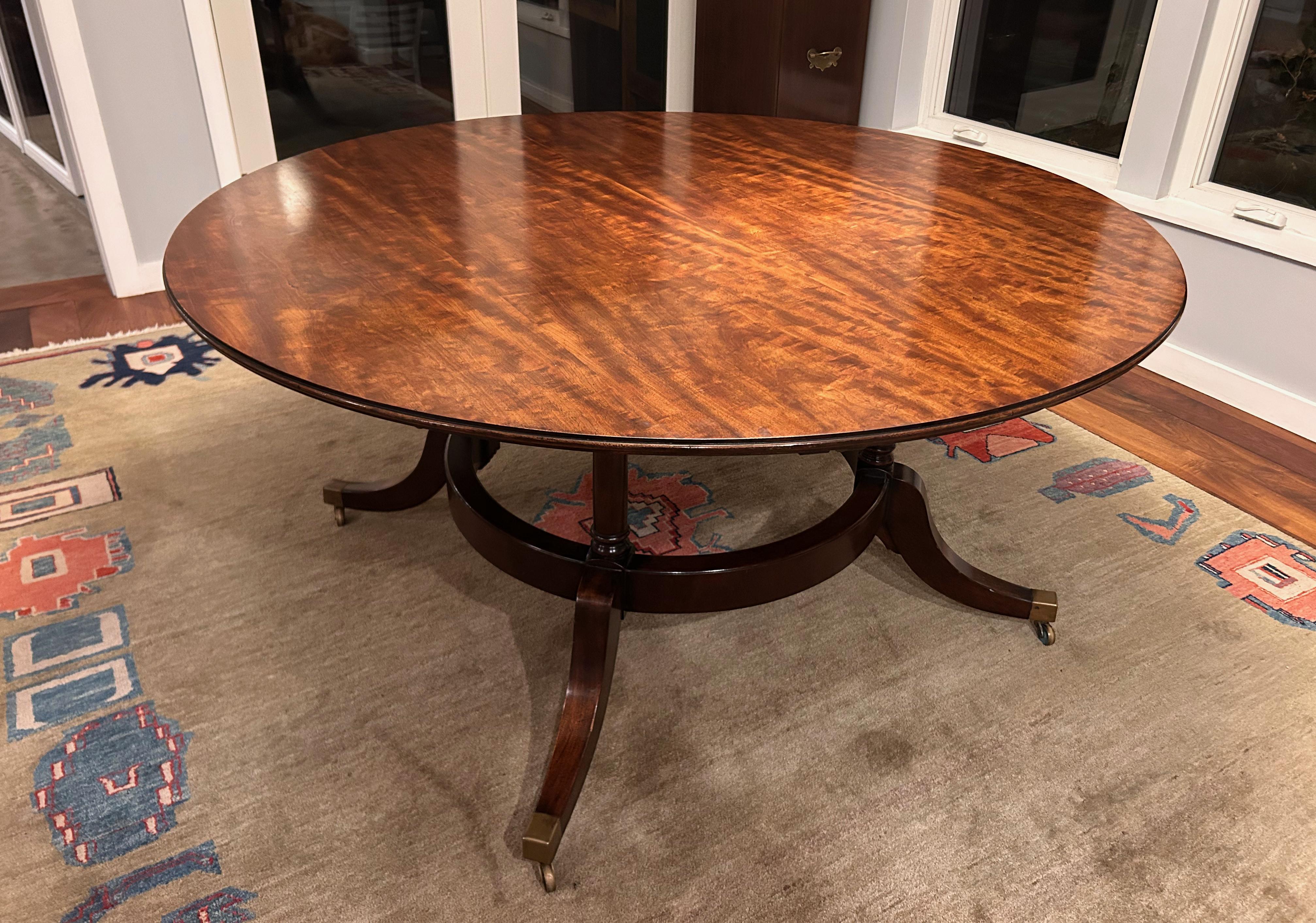 A 1940's round mahogany veneer dining table with fabulous crescent shaped leaves held in place by custom brass pins. Without leaves it is 60