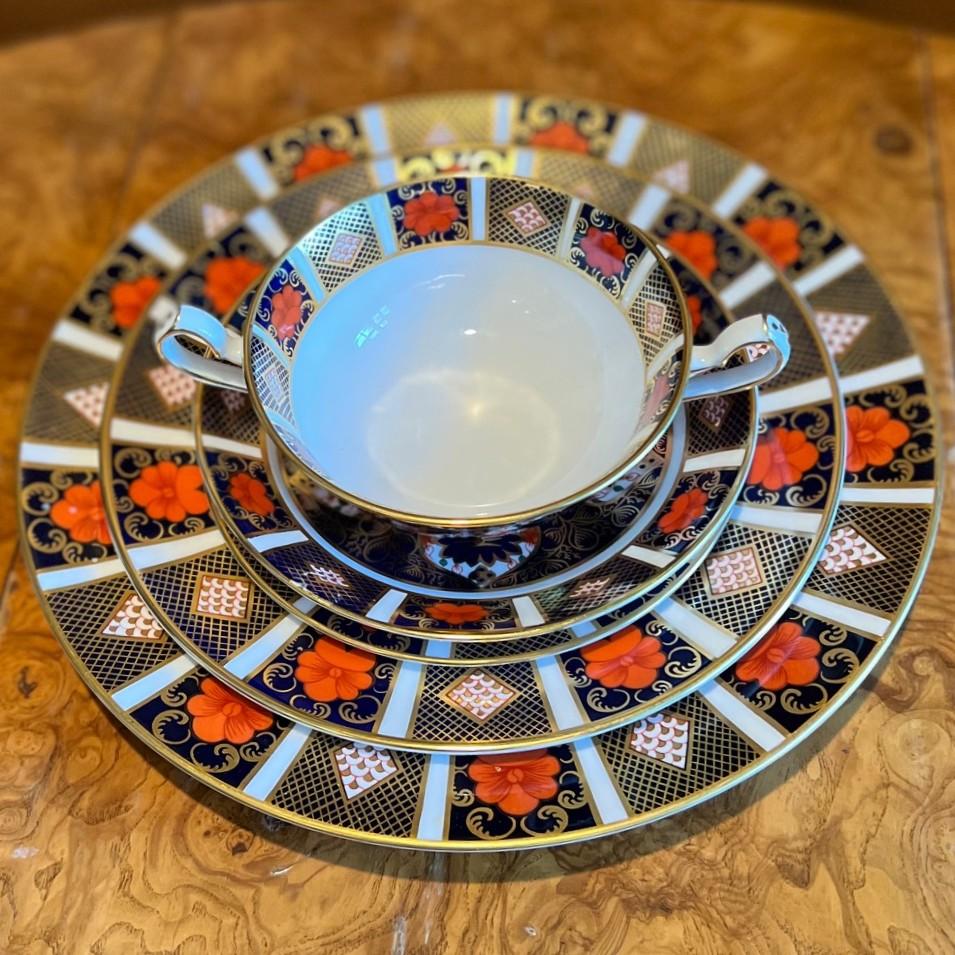 Juego de mesa de cinco piezas Royal Crown Derby Old Imari 1128 para la cena. El juego consta de un plato de cena, un plato de ensalada, un plato auxiliar, una taza para sopa de crema con pie y un plato para sopa.  Un ejemplo intemporal de la