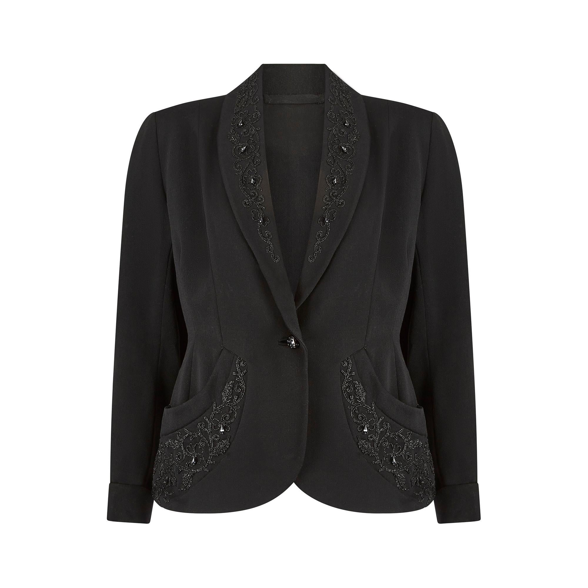 This late 1940s Sally Slade black blazer jacket has the most incredible beaded detail on the lapels and pockets. It is cut in a classic New Look 'bar' style shape, with rounded front hem and long lapels. It has original padding in each shoulder to