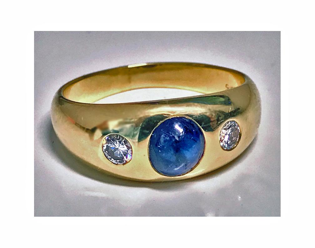 14-carat Cabochon sapphire and diamond ring, circa 1940. The ring centering a cabochon blue sapphire, gauging approximately 6.5 x 5.0 x 3.5 mm, with early round cut diamond on either side, approximately 0.30 ct, total diamond weight, average VS2
