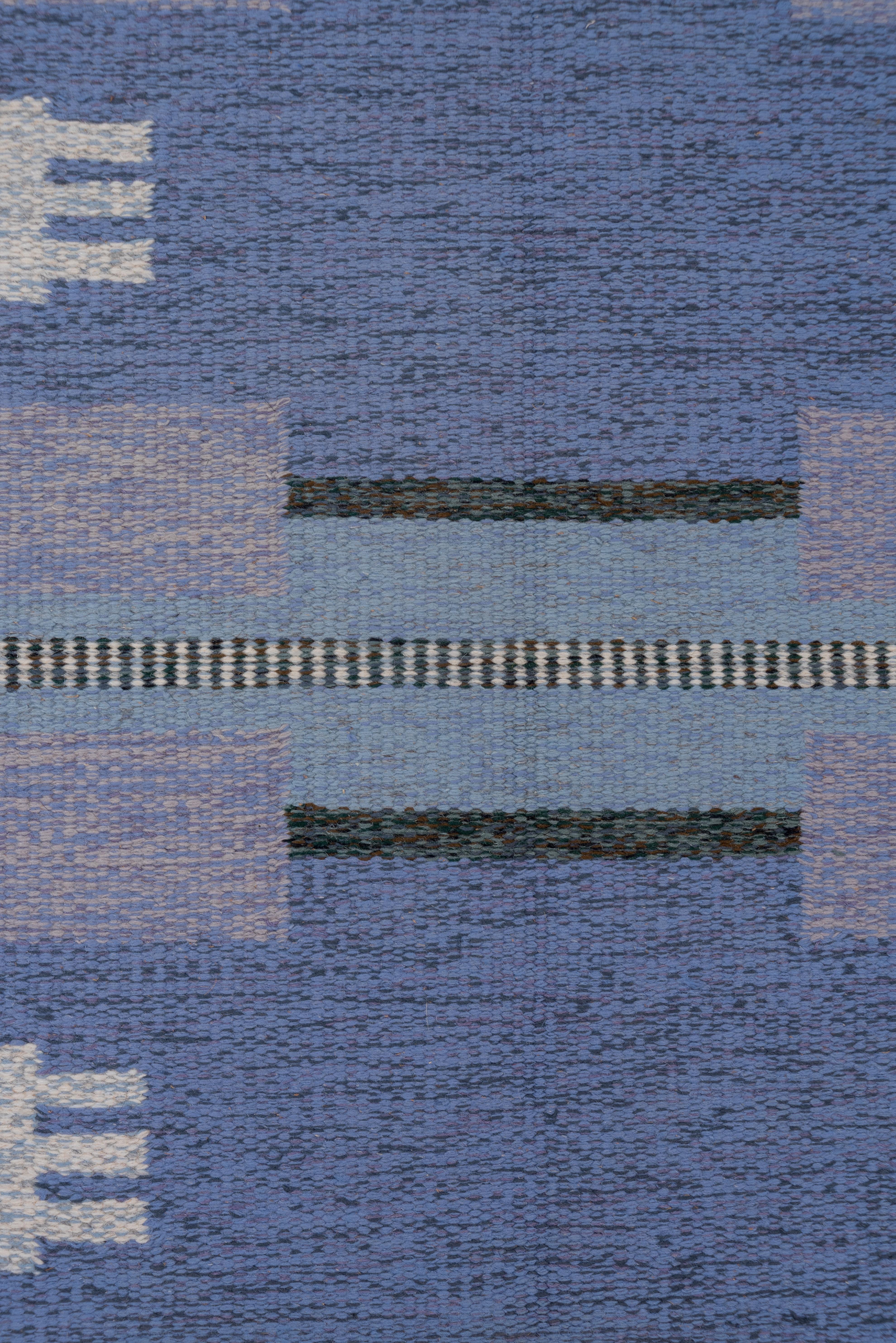 A vibrant field of striating blues n four broad horizontal bands against a lighter blue background. Charcoal gray border with added rectangles and partial lines. Cream stepped devices with triple extenders. Blue end strips and finishing braided