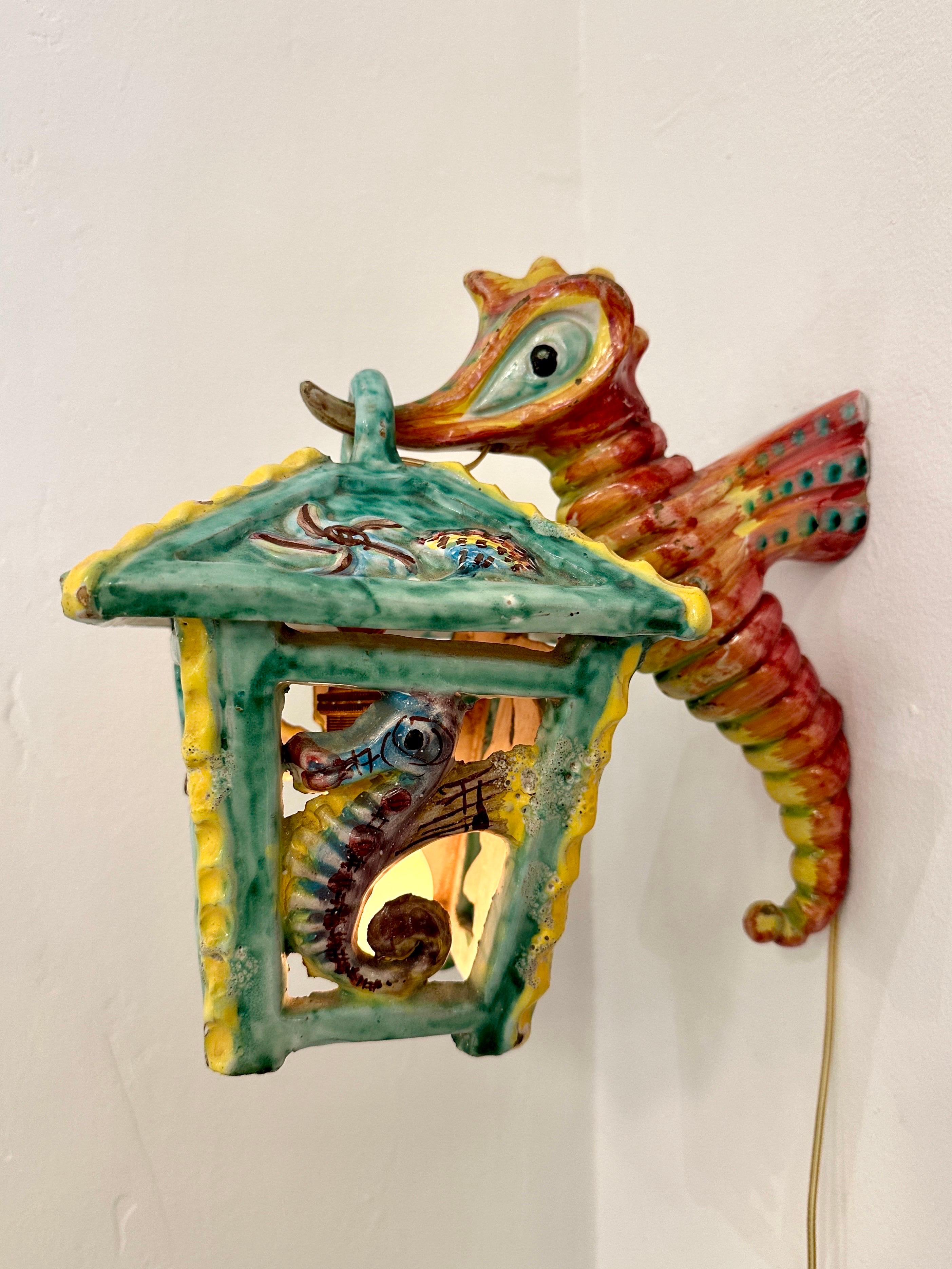 Cette lanterne murale italienne en maïolique représentant des créatures marines en relief et des couleurs vives est vraiment magique. Une seule ampoule fournit un éclairage suffisant - cette lampe peut être utilisée comme indiqué, fixée au mur OU si