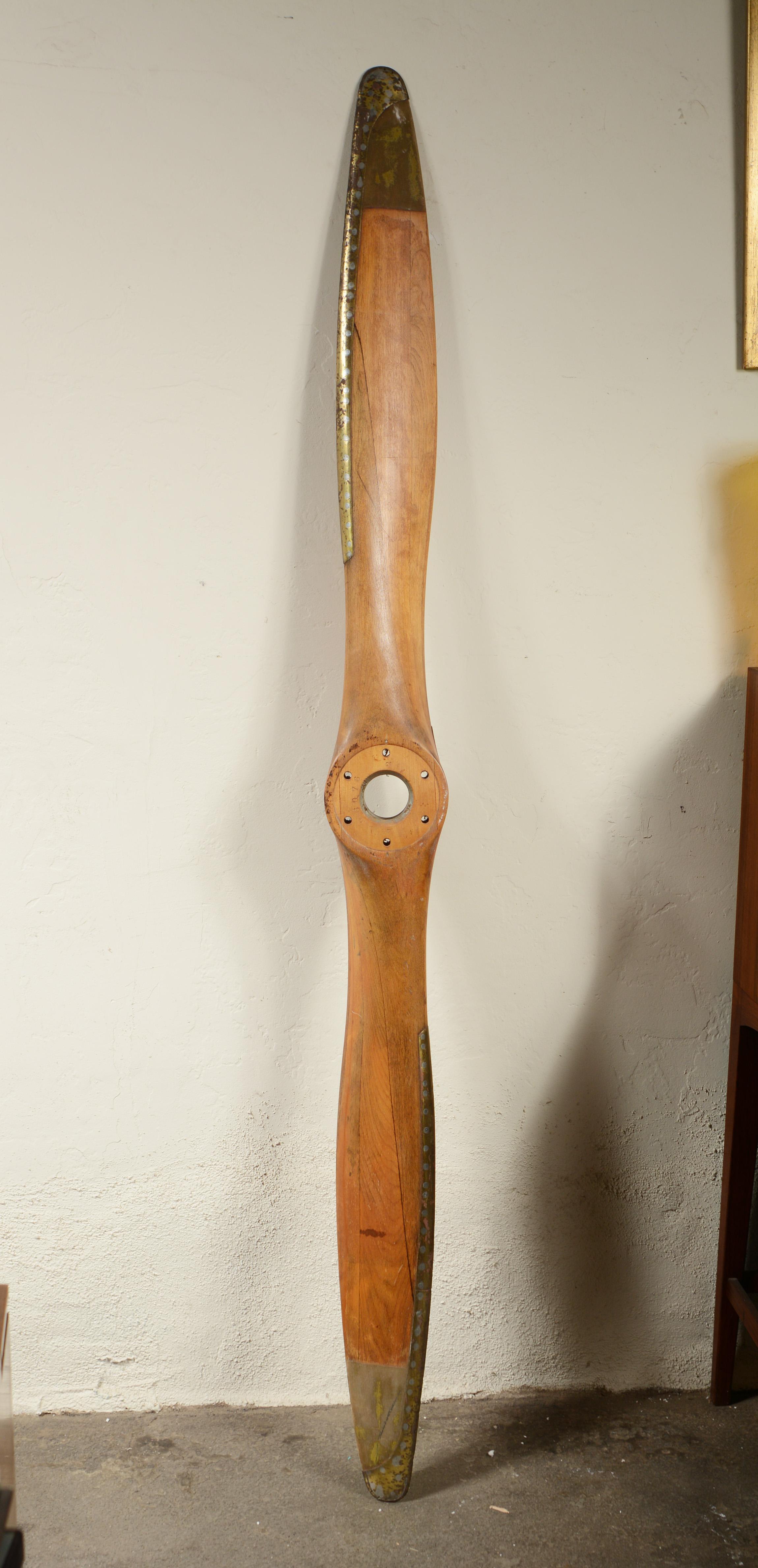 Wood airplane propeller made by Sensenich. The serial number dates this propeller to 1947. This would have been used on Aaronca, Piper and Taylorcraft planes. The wood is discolored in a few areas. There is a crack in the wood on the hub.