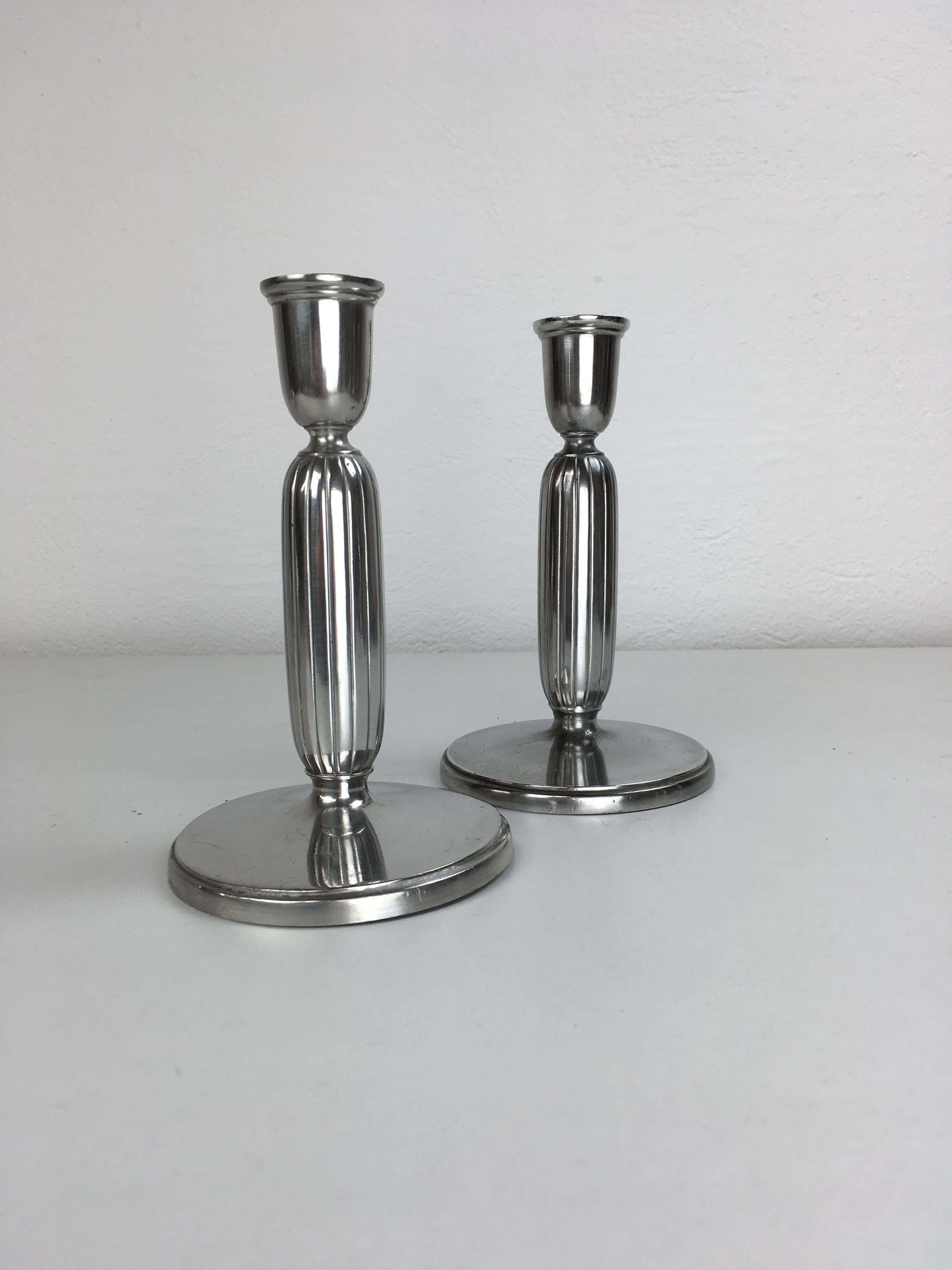 Set di due portacandele danesi Just Andersen in peltro art déco prodotti da Just Andersen A/S negli anni 1940 - 1950.

I portacandele sono in buone condizioni vintage e contrassegnati da Just. Il segno del triangolo di Andersens. 

Just Andersen