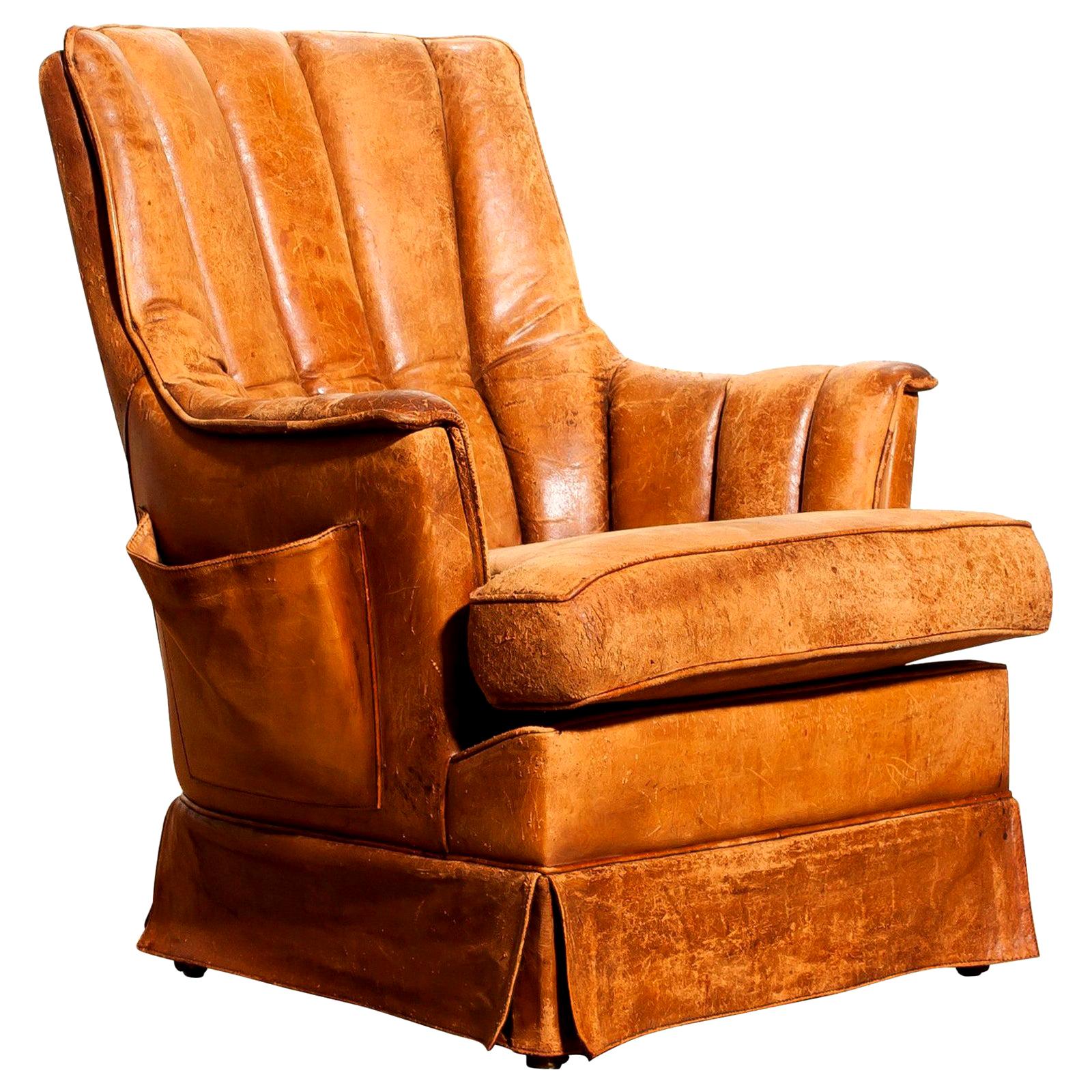 Fantastic club armchair from France.
This chair is made of leather with a skirt and a magazine bag on its side.
It has a greatly used patina.
Period 1940s.
Dimensions: H 85 cm x W 75 cm x D 68 cm x SH 46 cm.