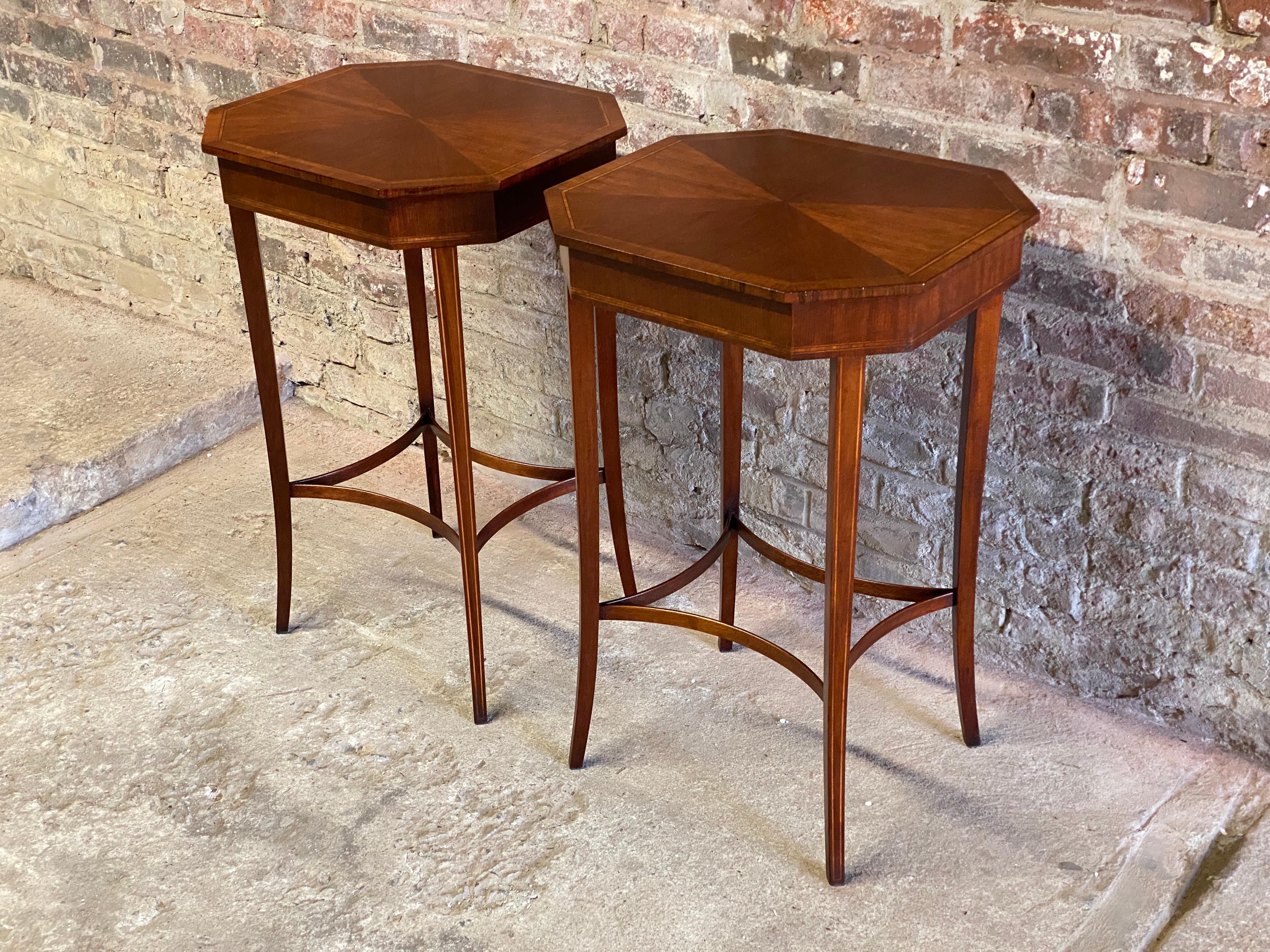 An exquisite pair of classic Sheraton style mahogany octagonal inlaid end tables. The pair features a wonderfully tapered sabre string inlaid leg with matched veneer tops with rosewood and satinwood banded edge inlay and a concave stretcher molding.