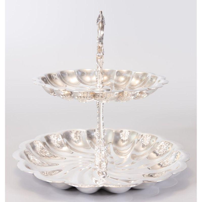 A superb vintage 1940s silverplate two tiered tray dessert server by F.B. Rogers Silver Co. Maker's mark on reverse. This lovely server has a beautiful scalloped design with an ornate handle, perfect for display or serving at your next party.

