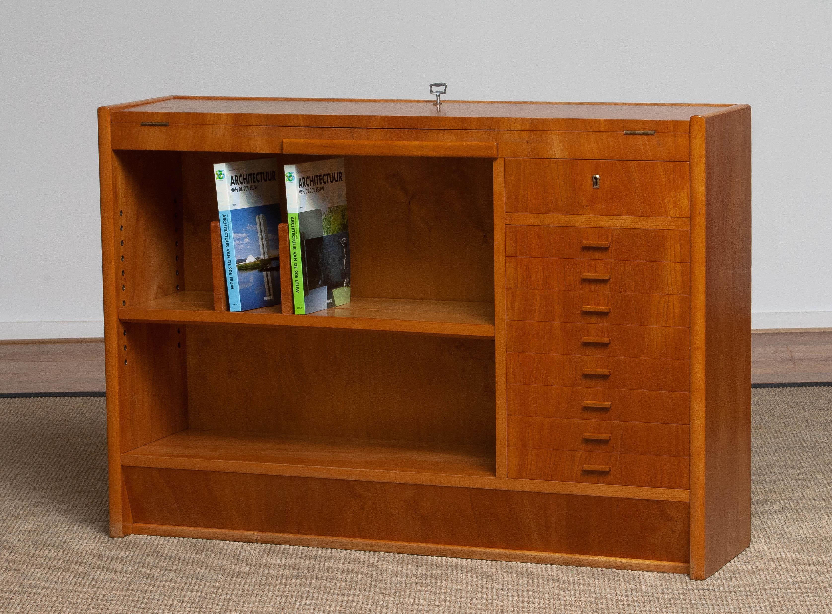Absolutely great quality and beautiful Scandinavian slim oak writing desk or working bench build in the 1940s in Sweden consists; One adjustable bookshelf with adjustable supports a open folding top with two lower section to store.
Eight drawers