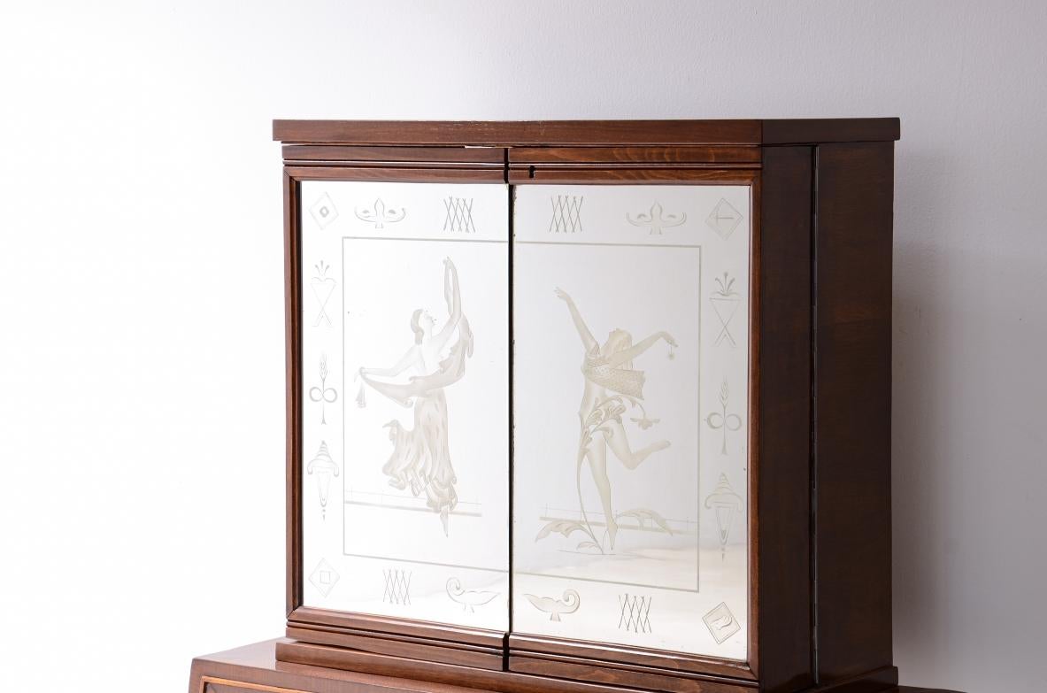 COD-2790
Pequeño bar elegante con dos puertas de espejo en la parte delantera con figuras y decoraciones grabadas.  

Fabricación italiana años 40

110 x 40 h 110 cm