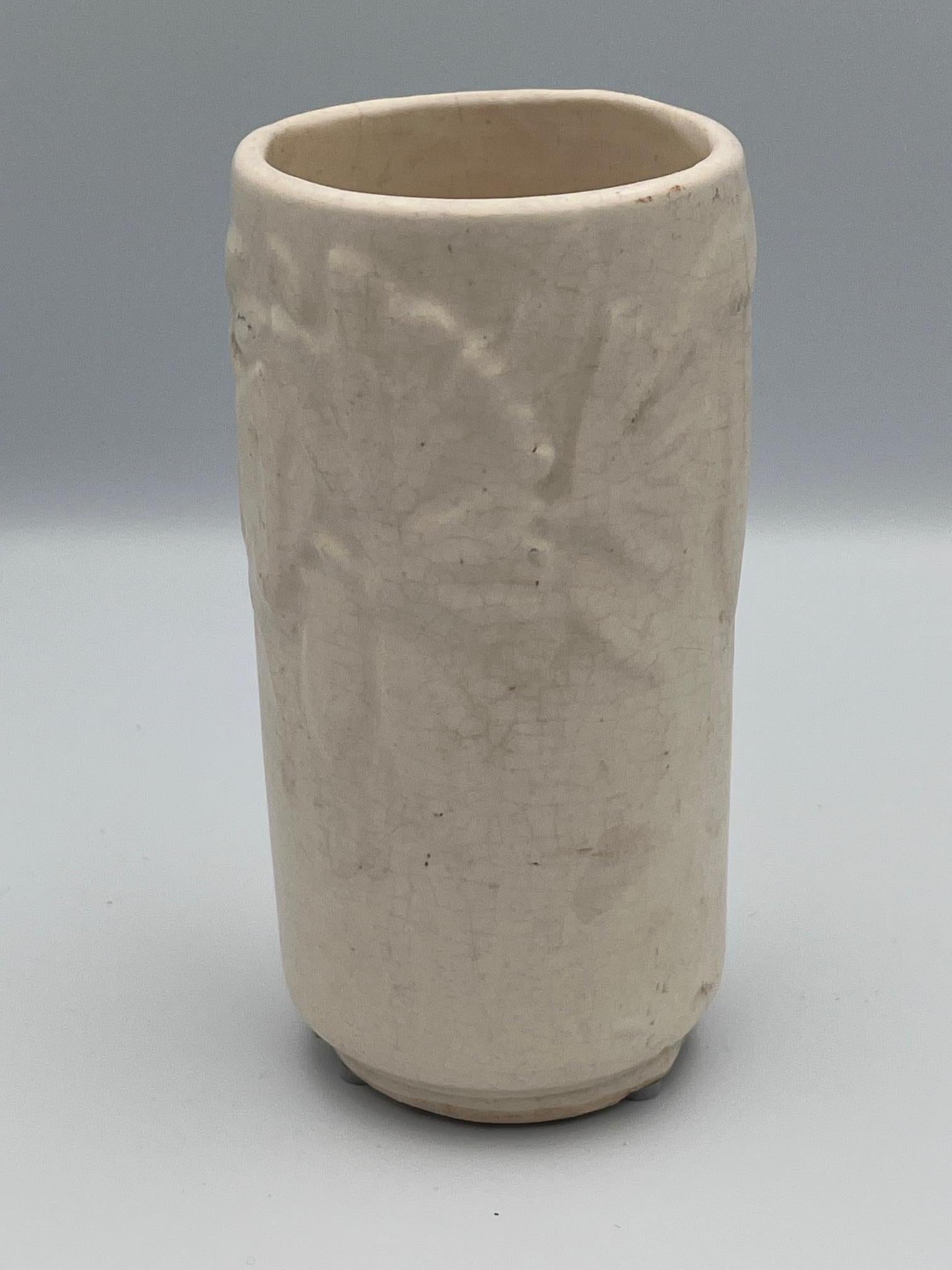 Questo piccolo vaso cilindrico McCoy Butterfly è un esempio straordinario della maestria dell'azienda, con un bellissimo motivo a rilievo di farfalle che si posano con grazia sulle foglie. Rifinito con un morbido smalto bianco crema, questo pezzo