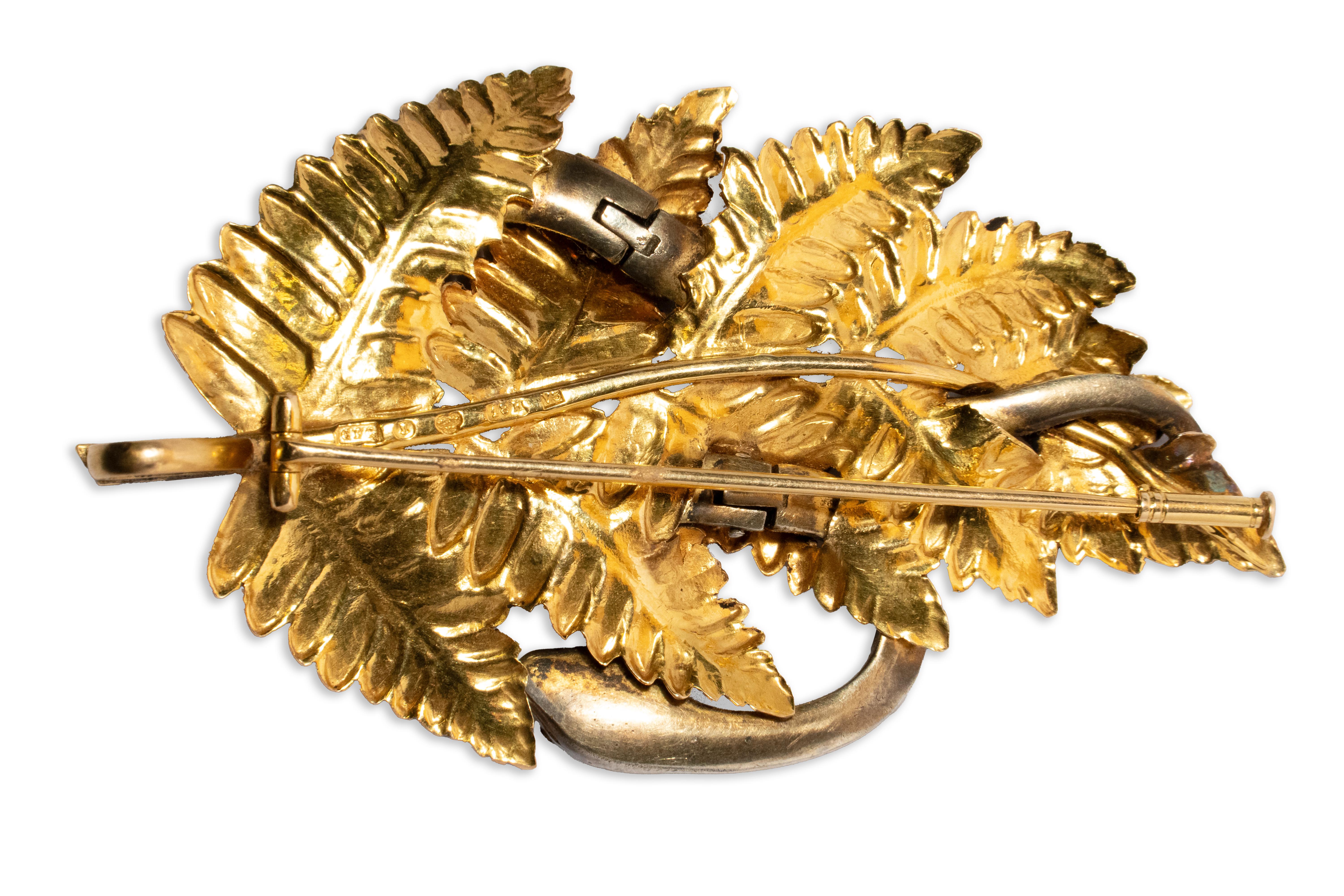 Capture the allure of 1940's elegance with this exquisite Snake in Fern Brooch/Pendant crafted in 18k gold by renowned Swedish court jeweler C.F. Carlman in 1947. Embracing the allure of nature, this piece features a captivating snake entwined