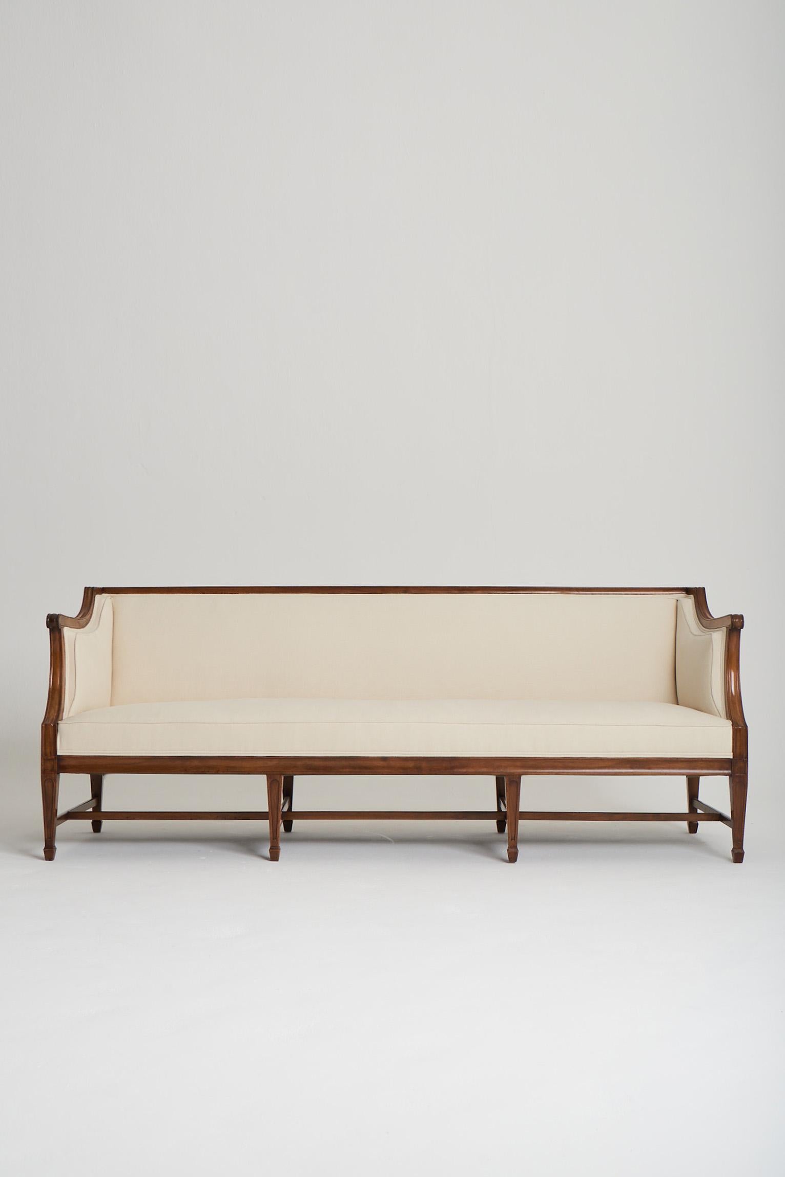 A solid mahogany sofa by Frits Henningsen (Danish, 1889–1965).
Fully reupholstered in ivory linen. 
Denmark, Circa 1940.