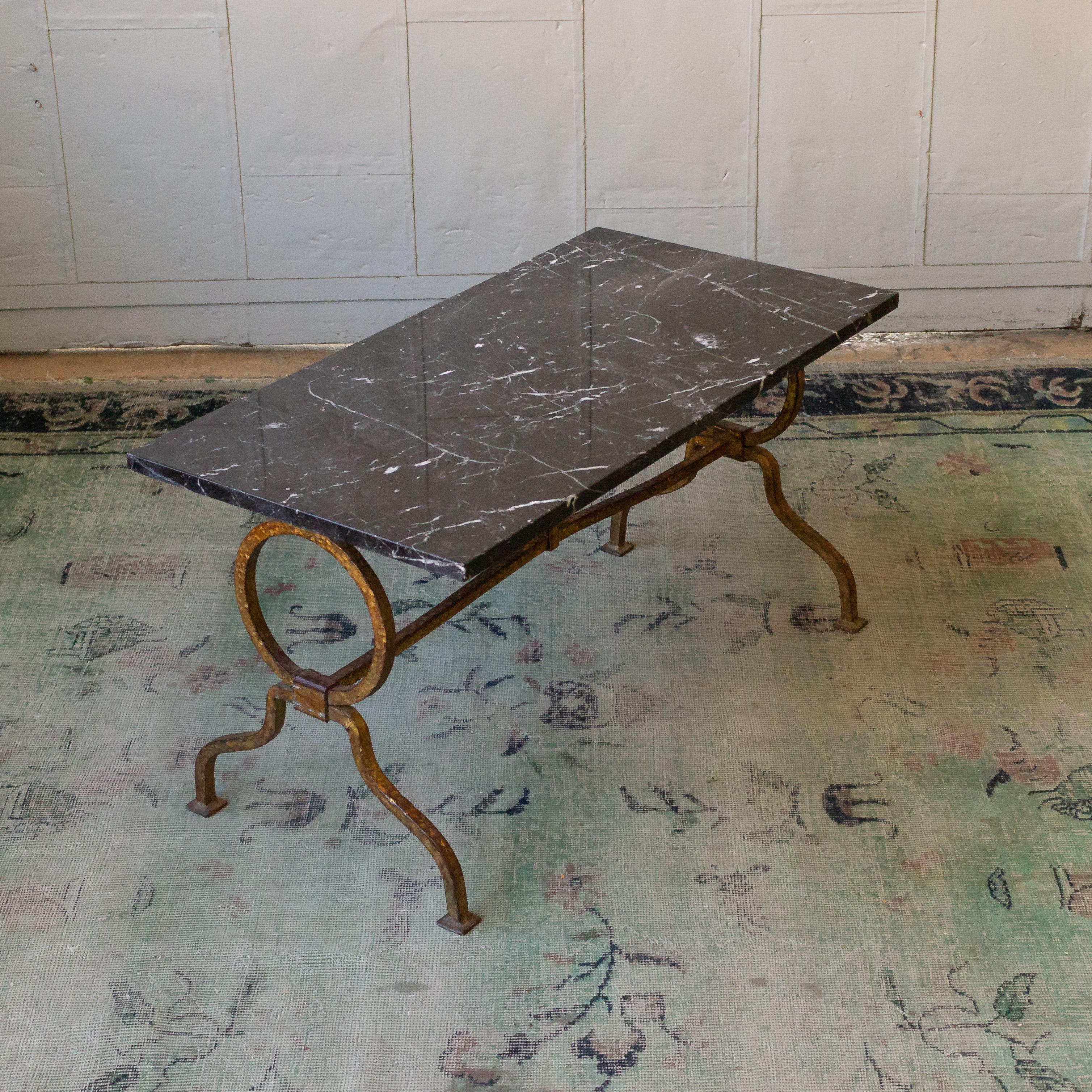 1940s Spanish gilt iron coffee table with grey marble top. The stone photographed on this table base has scratches and repairs made but has been polished.
 