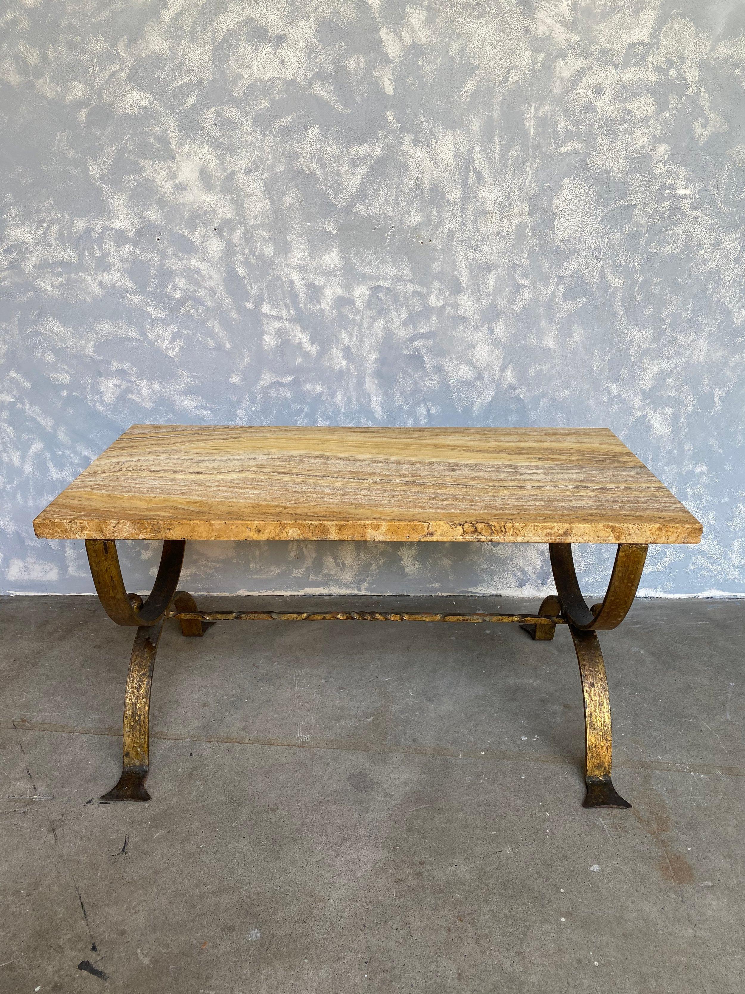 This Spanish marble coffee table from the 1940s features a stunning marble top with beautiful veining, showcasing rich patterns and vibrant hues. The natural variations in the marble add an element of uniqueness and elegance to the table's design.