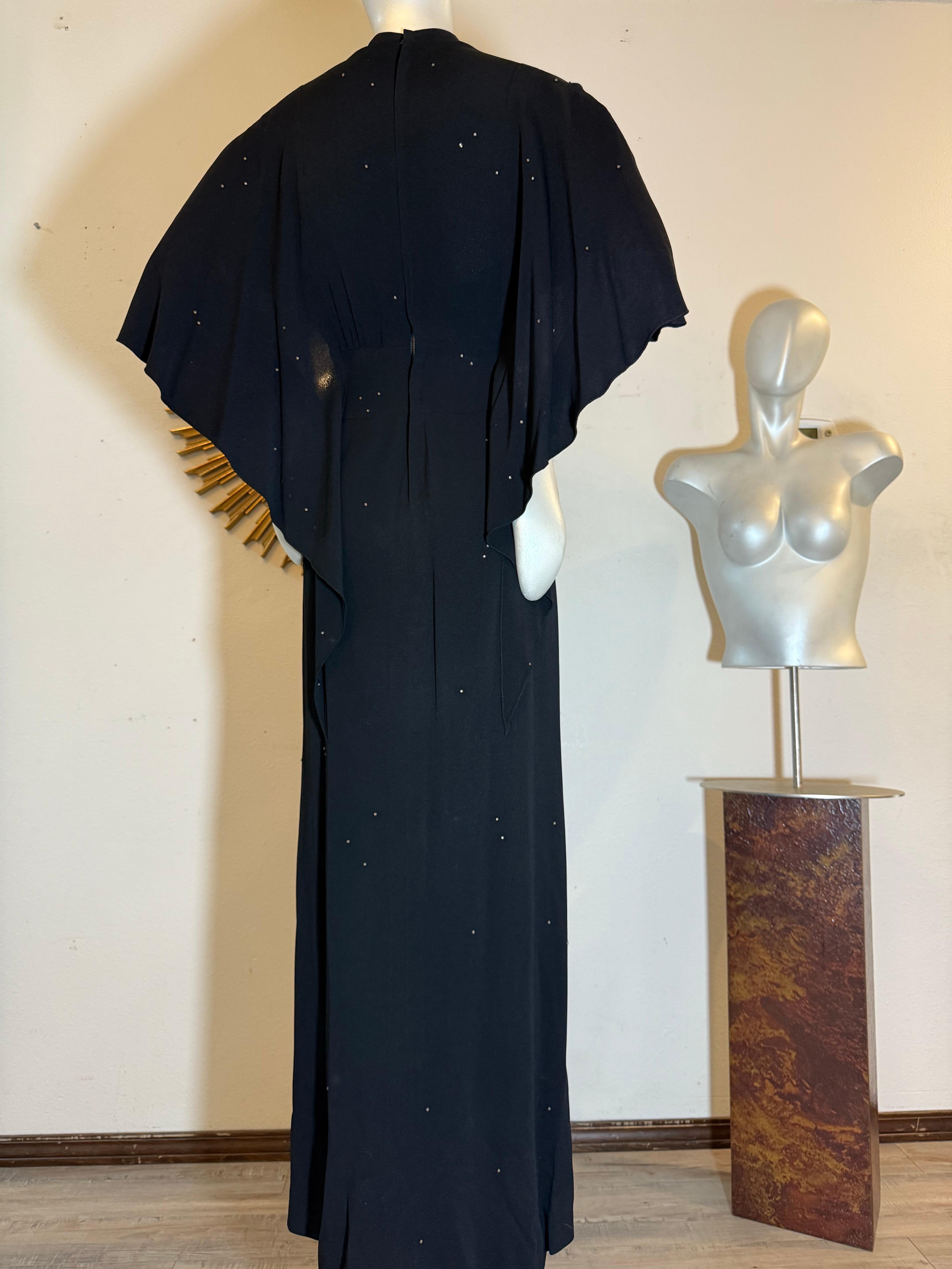 Spettacolare abito in crêpe nero di Adrian degli anni '40 con cappuccio sul retro e abbellimenti in strass:  Esempio incredibilmente raro del genio di Adrian, questo abito in crêpe di seta nero presenta una silhouette lunga e snella con dettagli di
