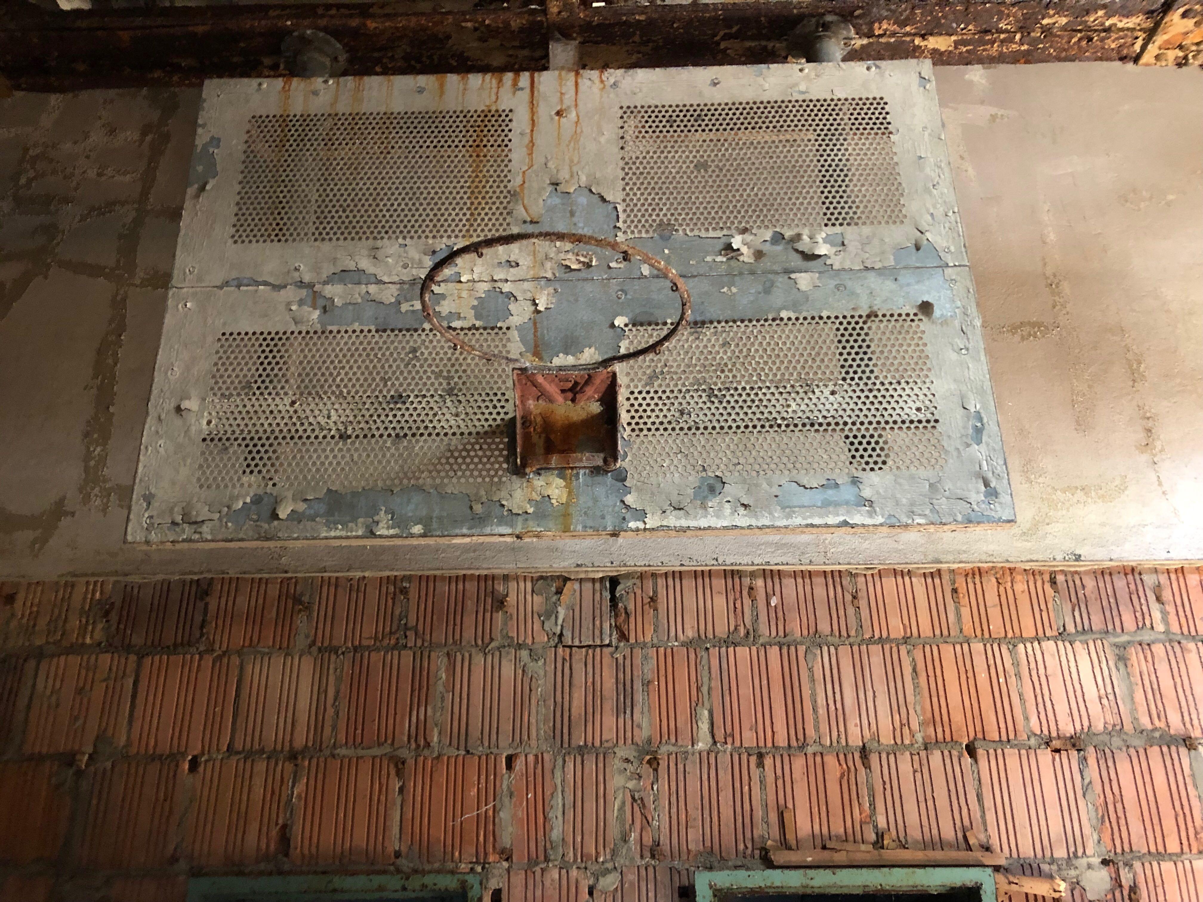 Industrial steel mesh backboard with original paint and steel basketball hoop. The pipes adjust to hang from ceiling. This can be seen at our 400 Gilligan St. location in Scranton, PA.