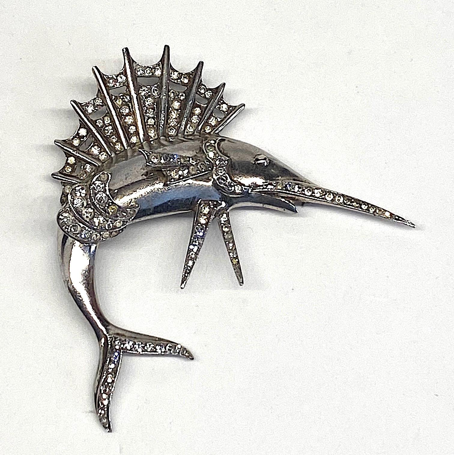 A lovely sterling silver and rhodium plate 1940s sailfish brooch. The body and fins are cast separately in sterling silver, hand soldered together. and then rhodium plated The fins, tail and sword are hand set with rhinestones. The brooch measures