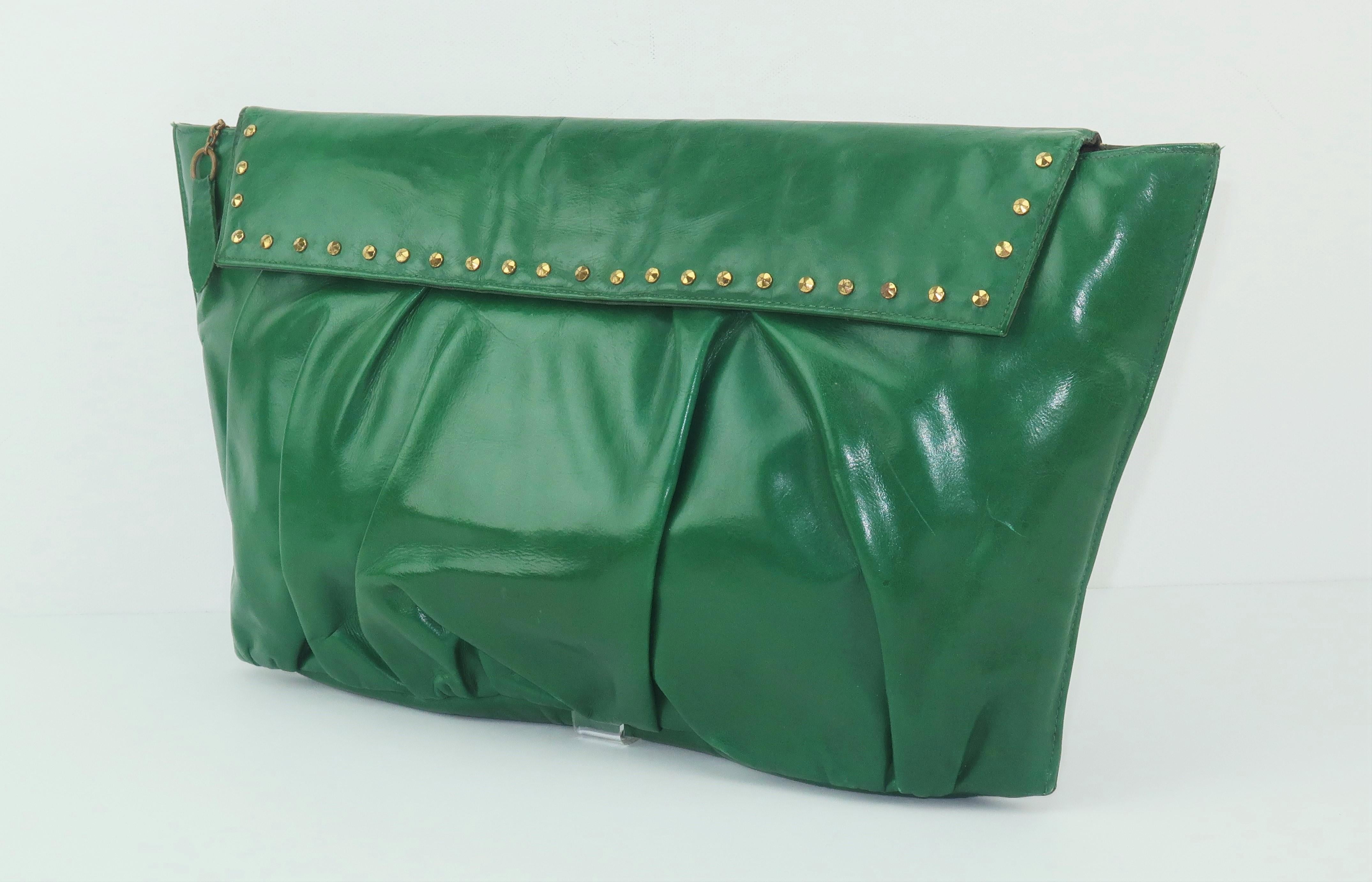 This 1940’s emerald green leather handbag has a fashion forward look with brass faceted stud accents that are as stylish today as in the past.  The trapezoidal silhouette and ruched leather body are eye catching details and the manageable size is
