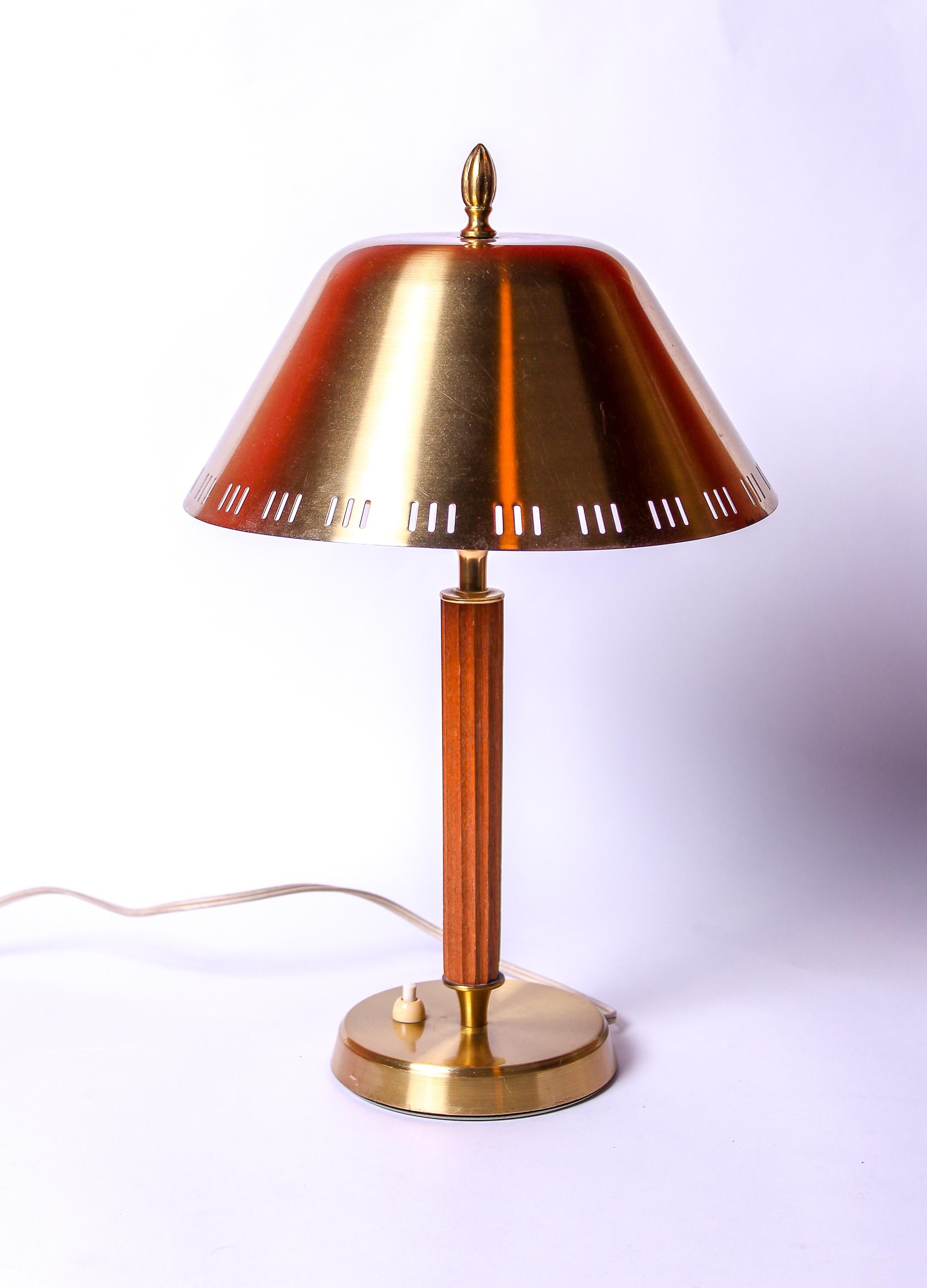 A high quality desk lamp made in Sweden during the 1940s. The lamp is made out of brass and teak and has a perforated shade. It is in good vintage condition and it is fully functional. The shade has some minor bend. Marked FAB. 

The shade can