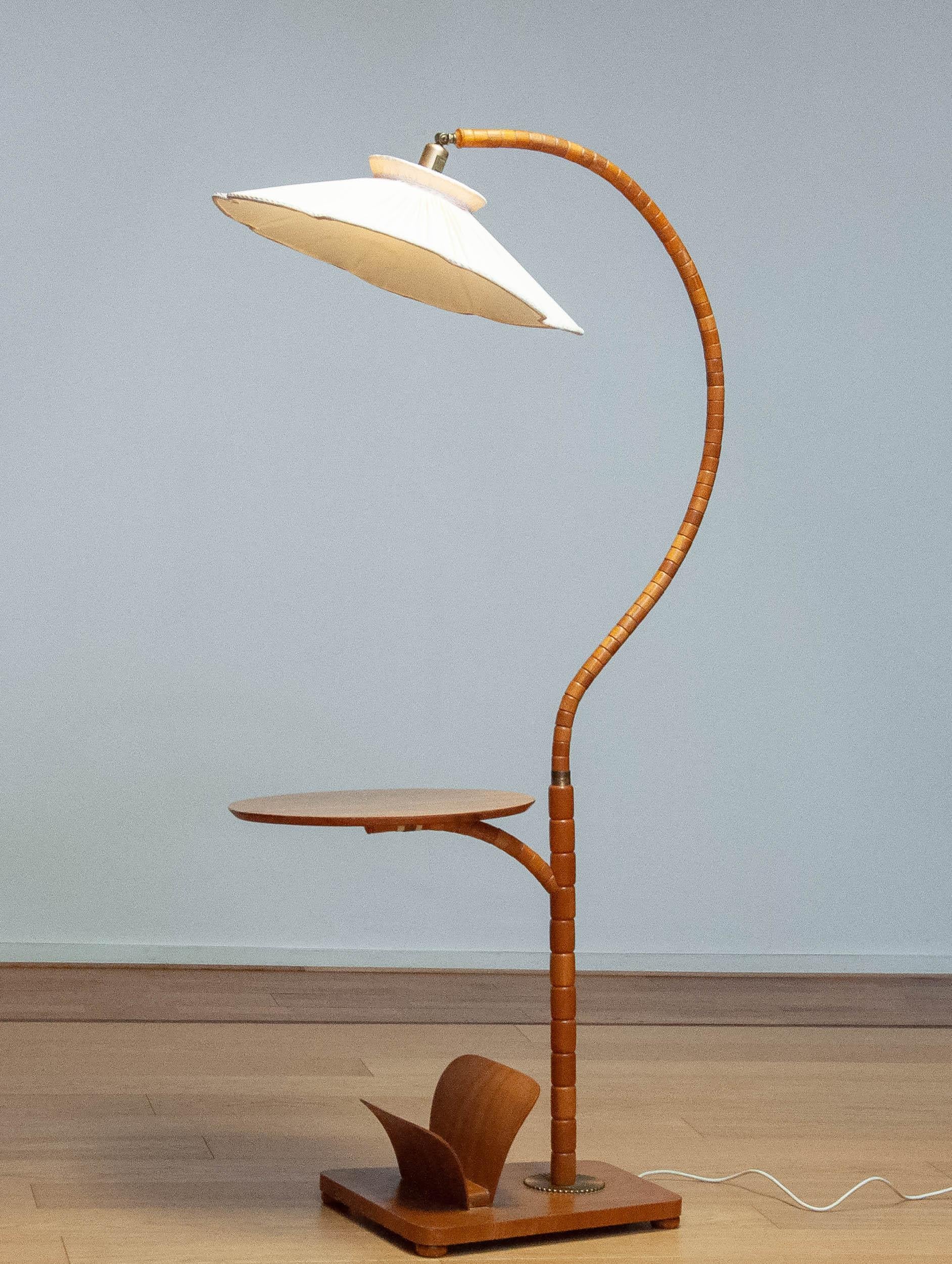 Absolutely beautiful and very rare Art Nouveau floor lamp made in the 1940s in Sweden by IWO in Mariestad.
The lamp is made of Elm wood combined with a table and magazine rack also in Elm. Table top is veneered in Elm and in good condition.