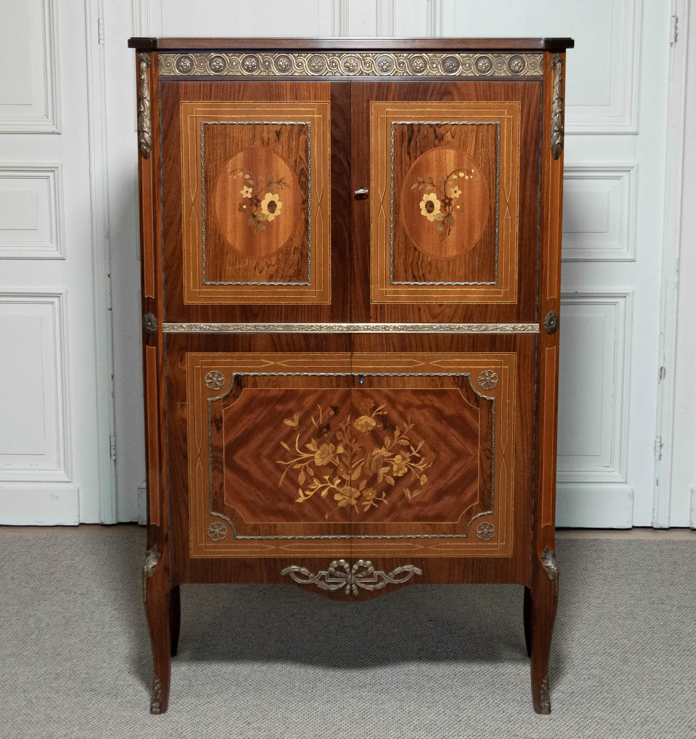 This exquisite 1940s Dry Bar is a remarkable example of Swedish Grace design, masterfully crafted from a luxurious blend of mahogany, beech, teak, and elm woods. The cabinet features intricate floral inlays, showcasing exceptional artistry and